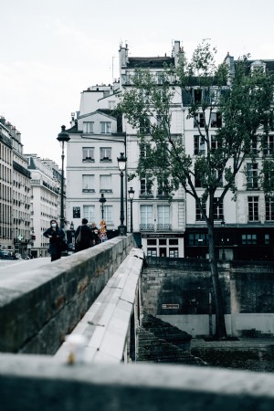 Les gens marchent sur un pont de pierre près des bâtiments Photo 