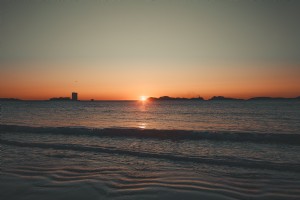 Marée roulant vers le rivage sous la photo du coucher du soleil 