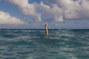 Signo de la paz de vacaciones en la foto del océano