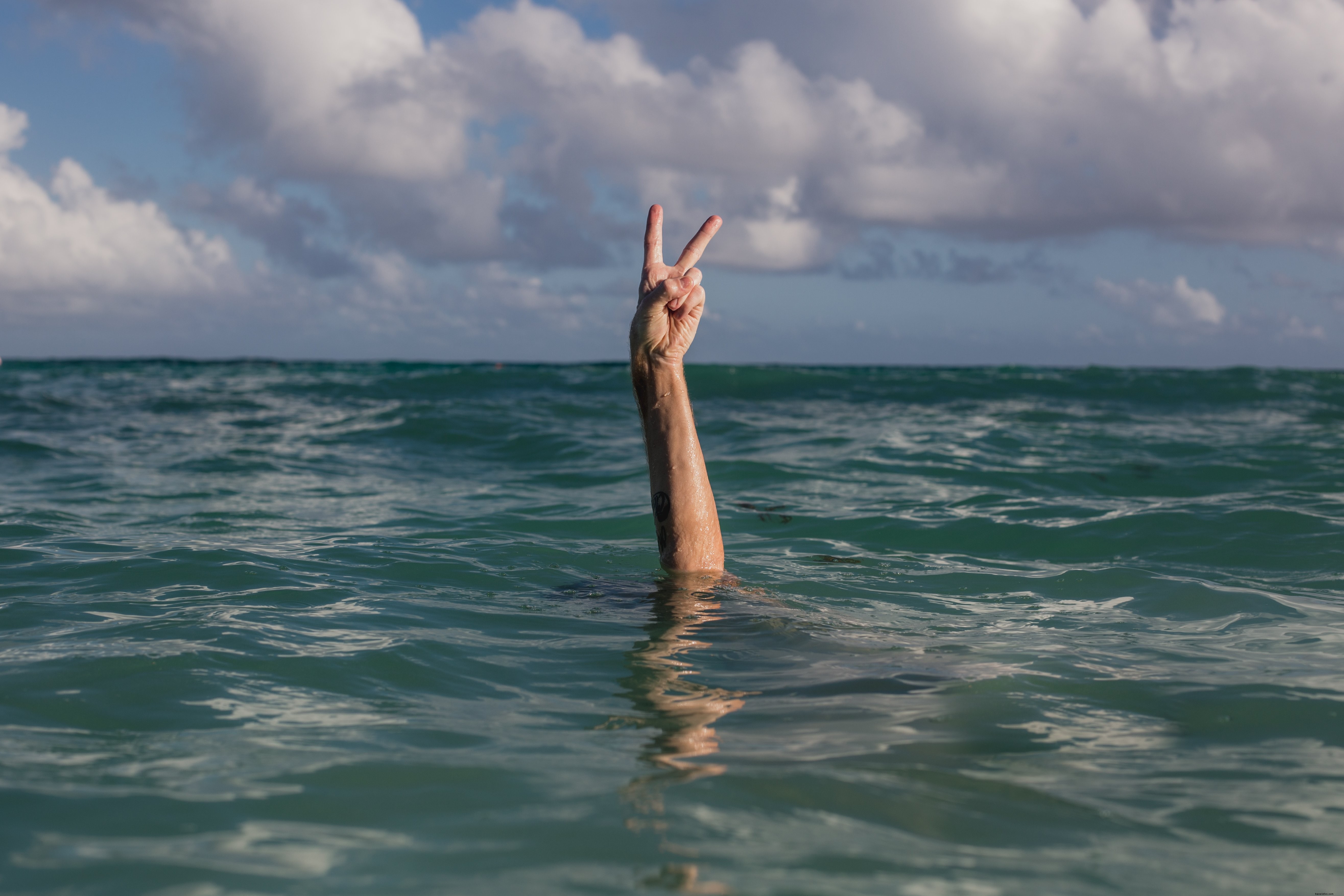 Mains signe de paix dans l eau Photo