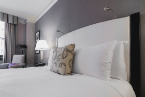 明るいホテルの部屋のベッドの写真