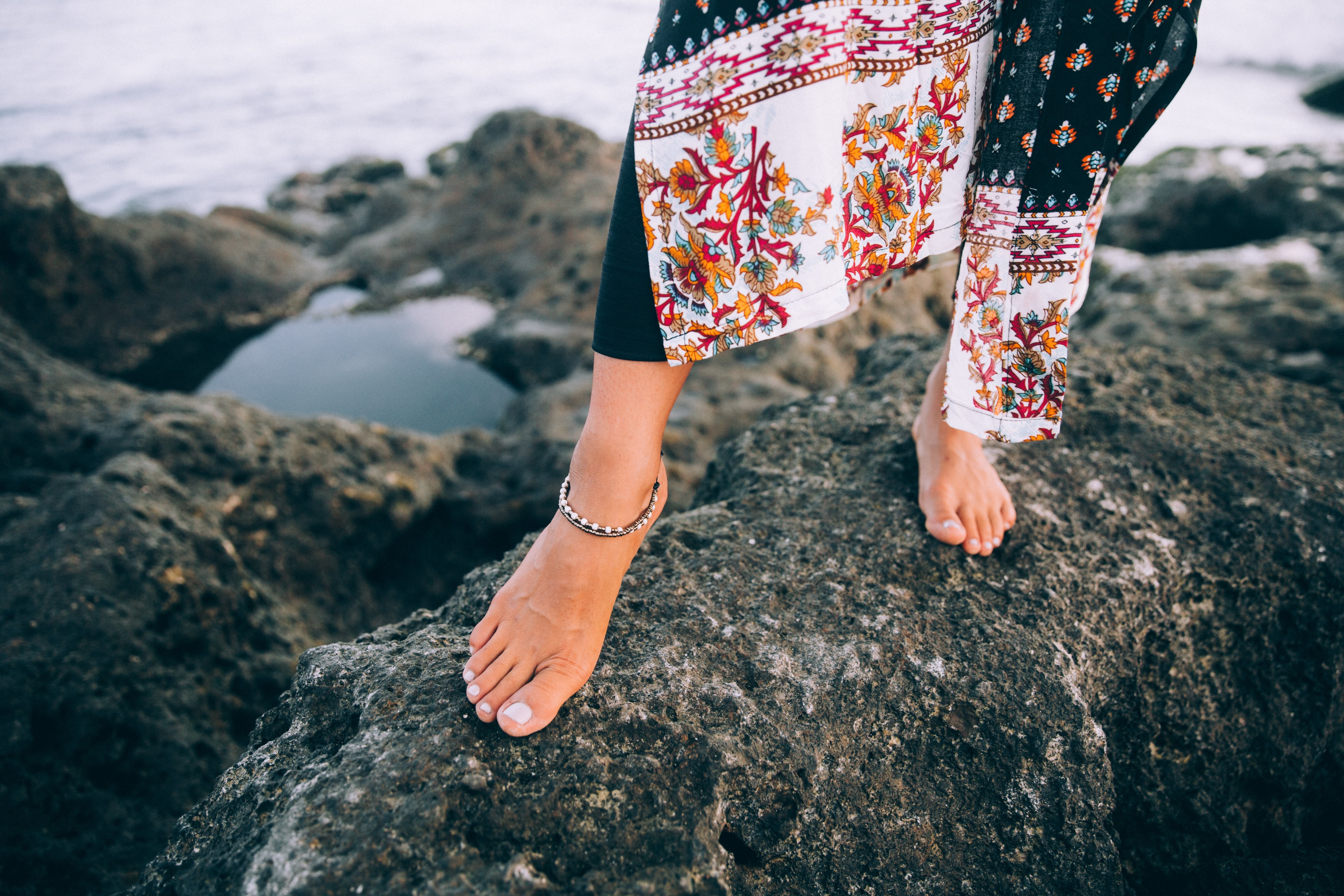 Una mujer con una túnica de playa que fluye camina por la playa Foto