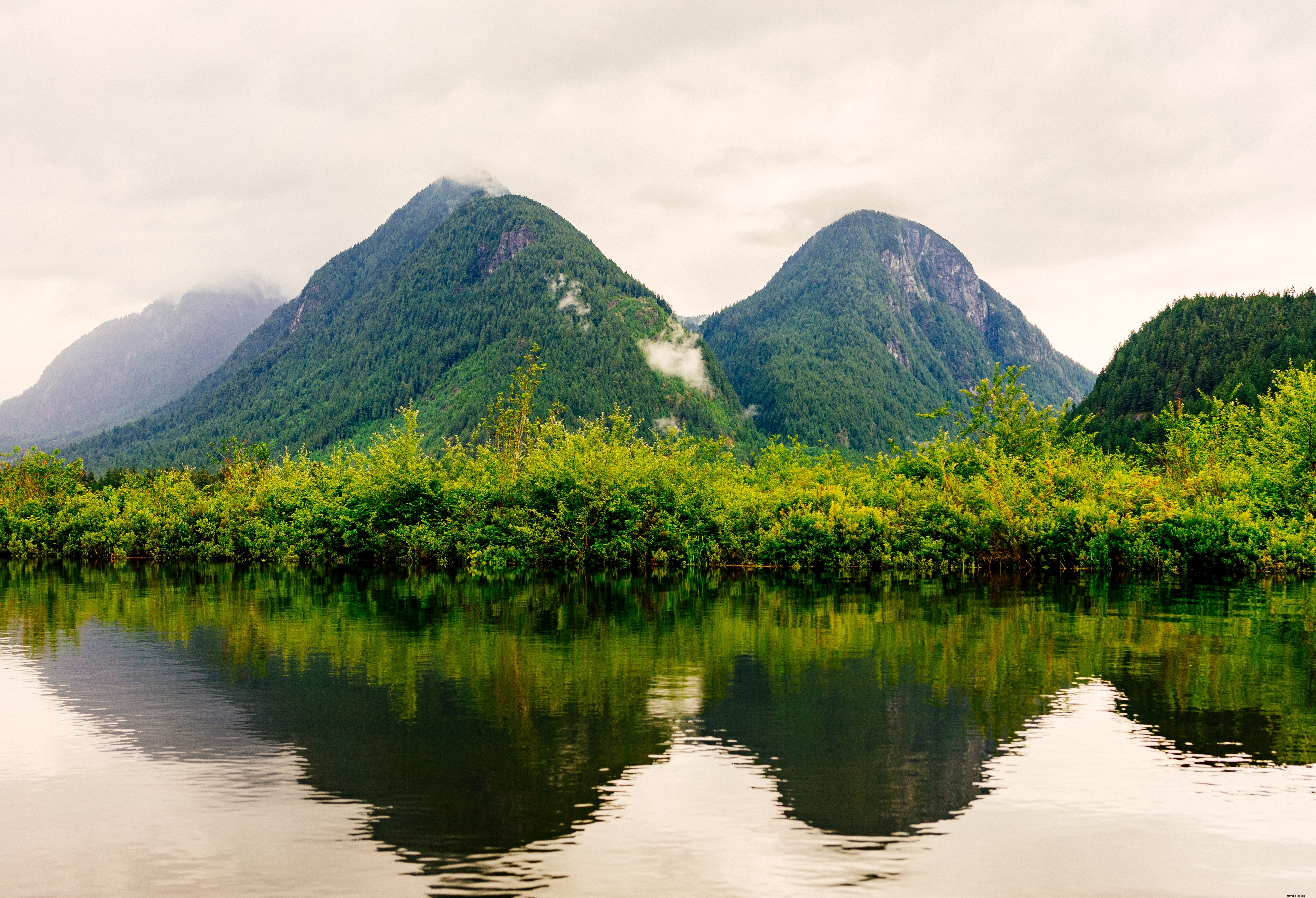 Foto de paisagem de montanhas verdes abaixo do céu com neblina