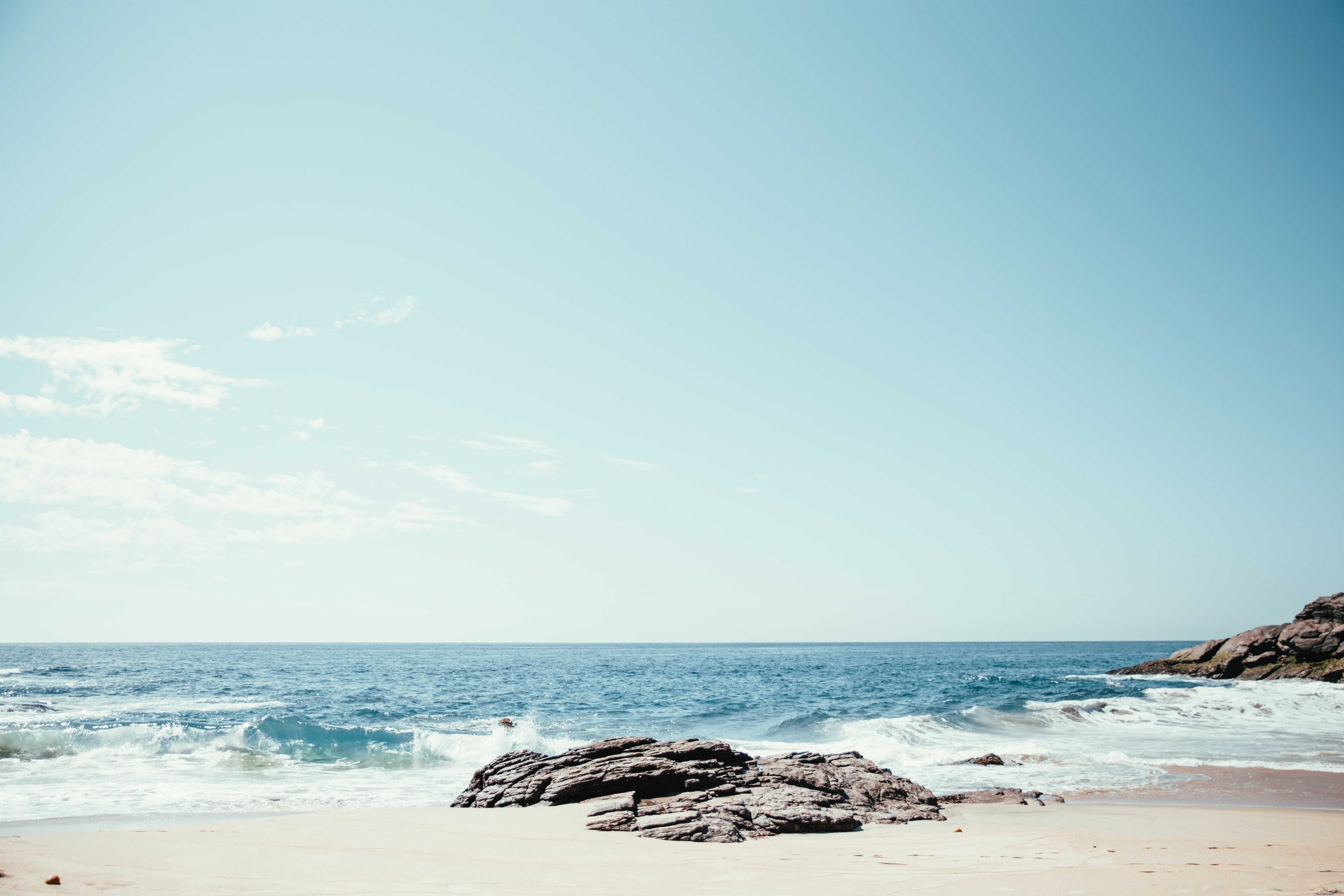 Les vagues s écrasent sur les rochers et le sable Photo