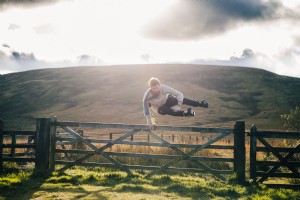 Hombre saltando valla por foto de campo