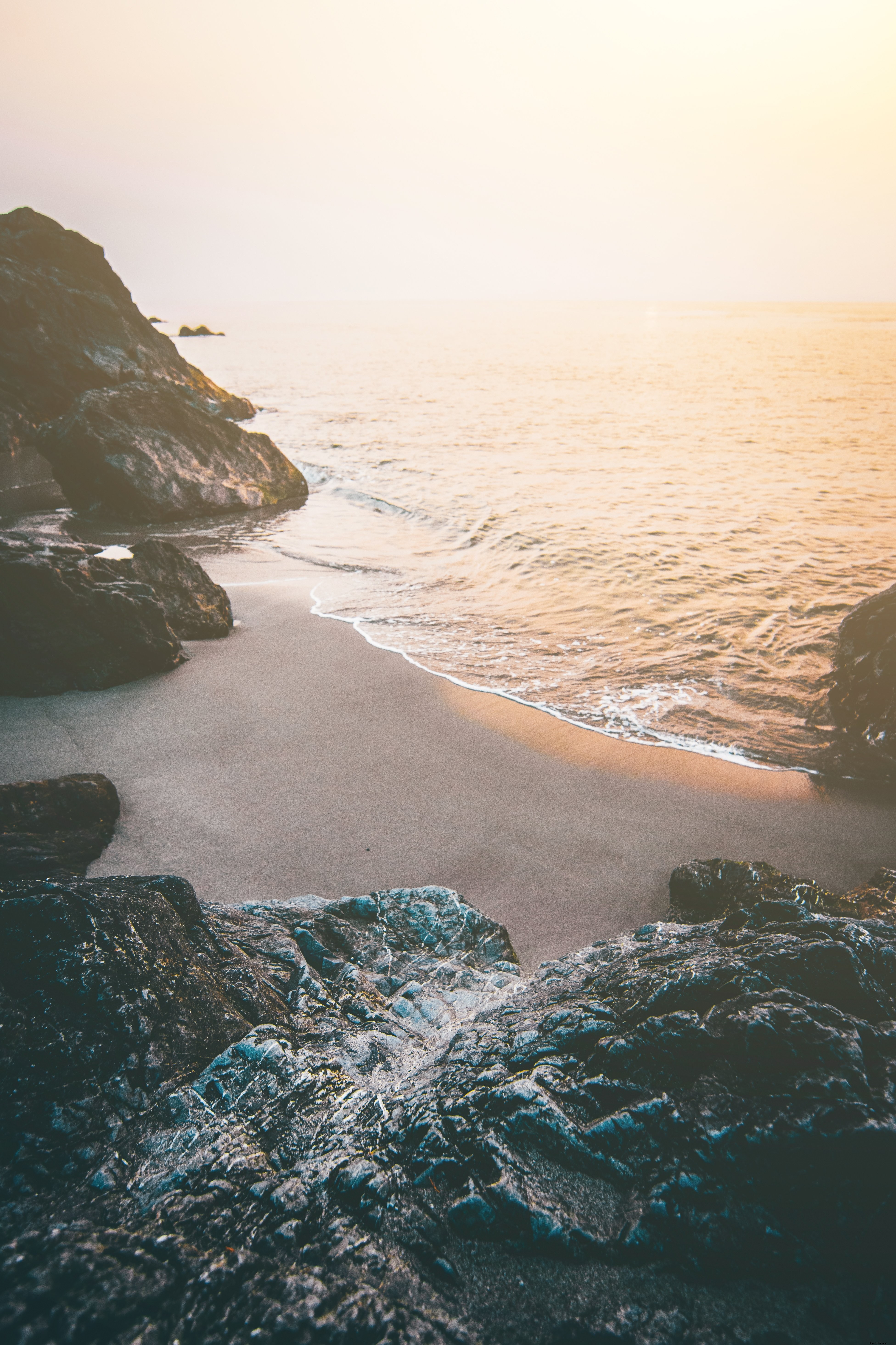 Foto de uma praia isolada rodeada por penhascos