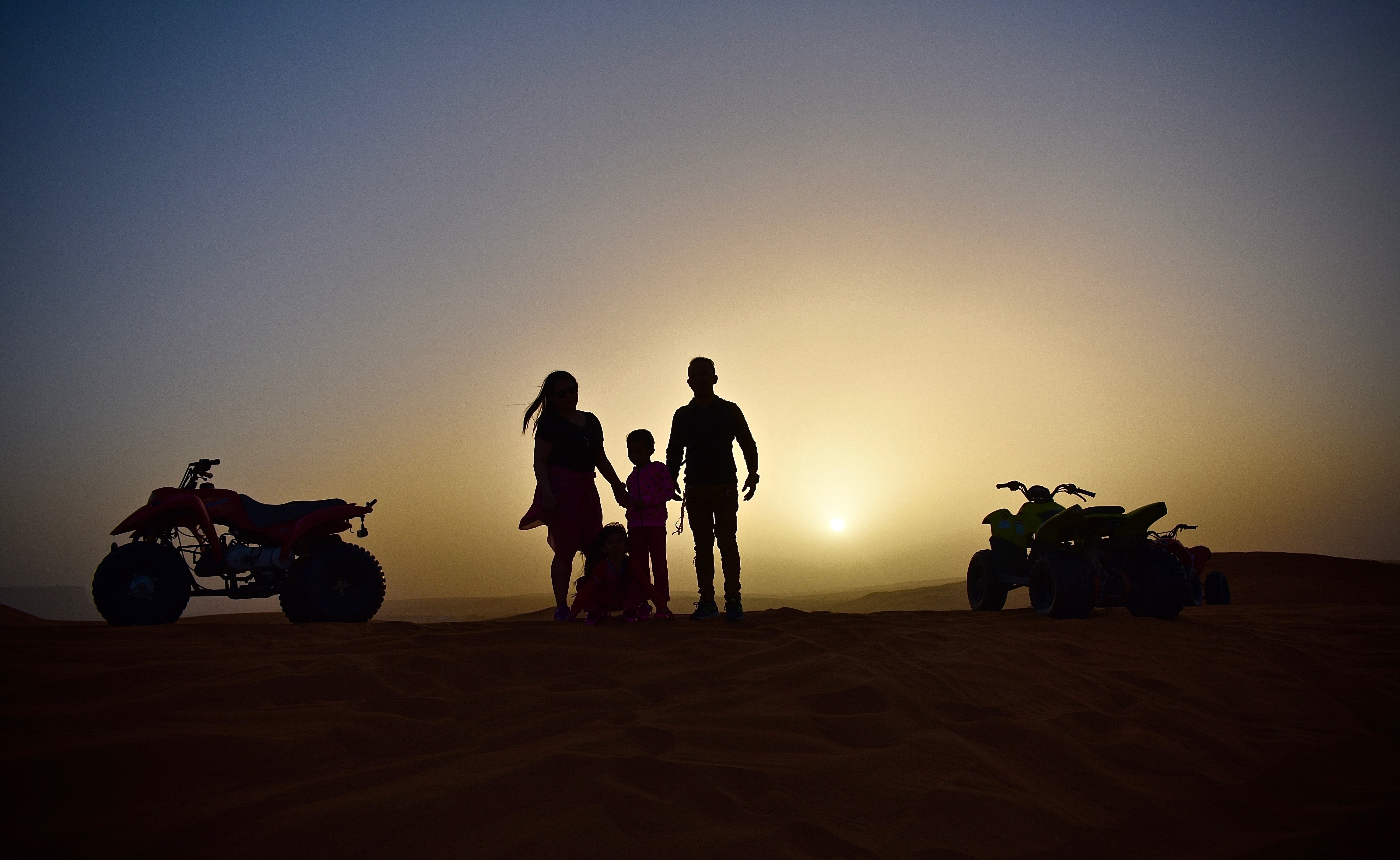 Foto de uma família em uma aventura de quadriciclo ao pôr do sol