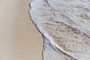 ビーチの砂の上の海の水写真
