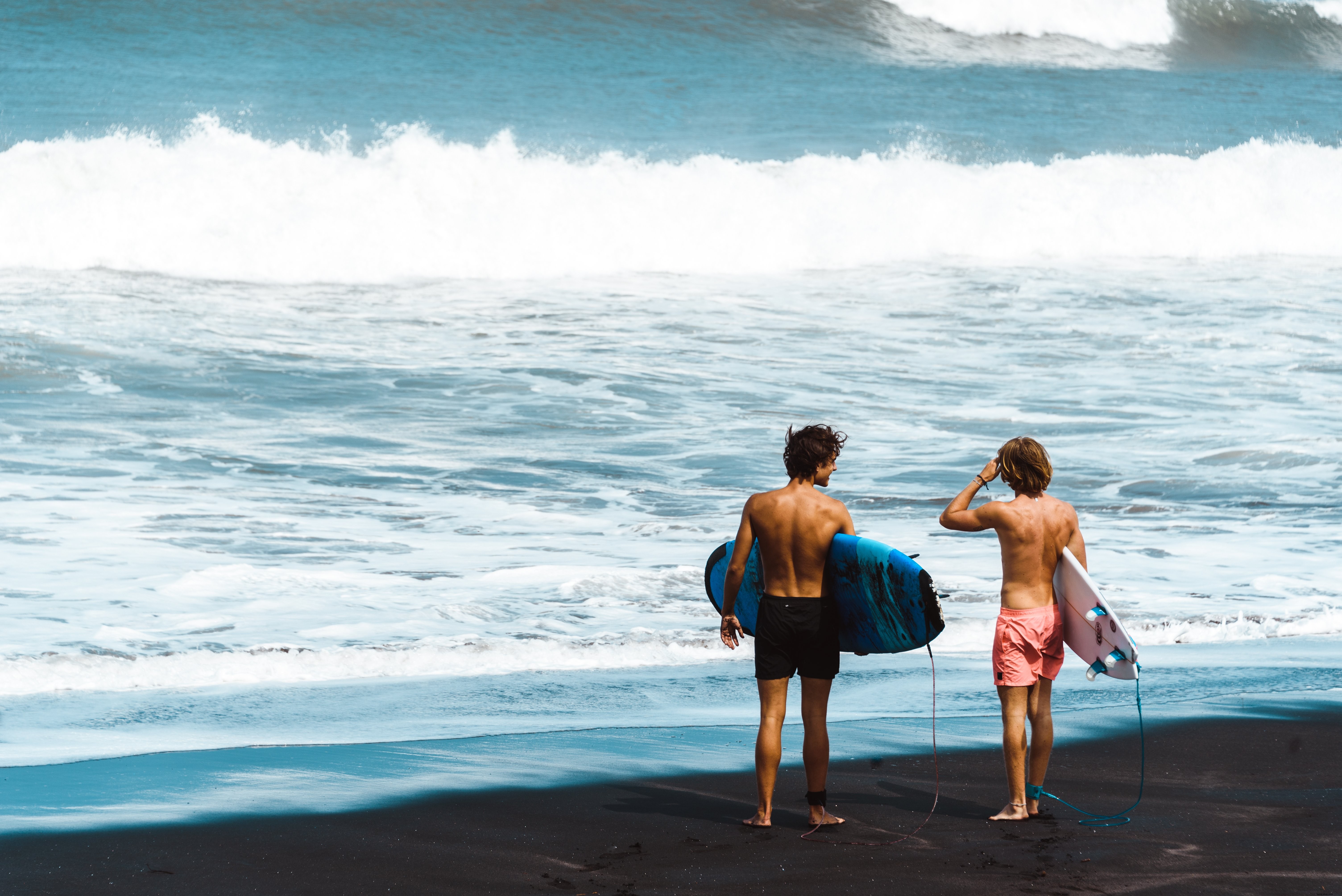 Surfisti in piedi sulla spiaggia foto