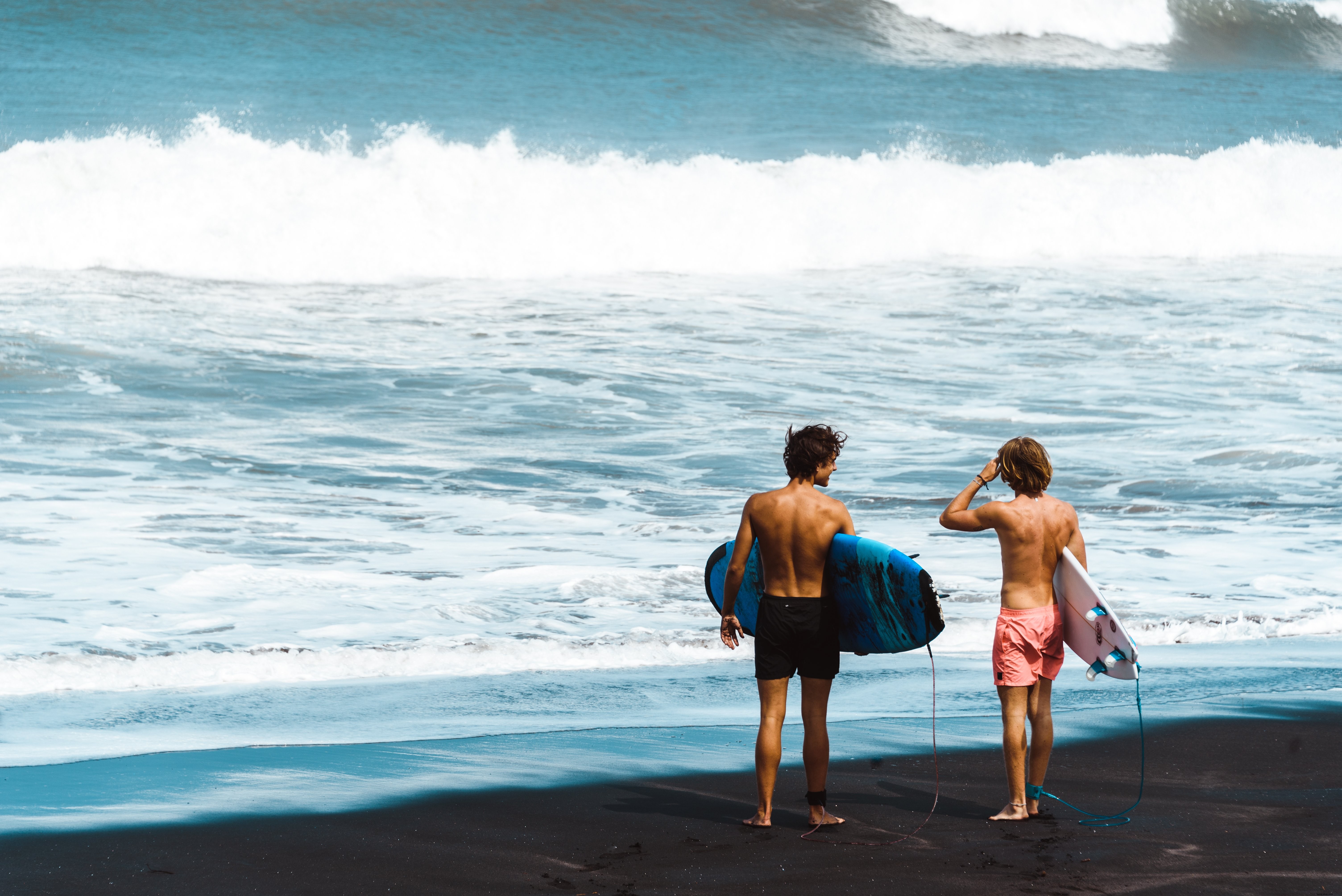 Les surfeurs se tiennent sur la photo du rivage