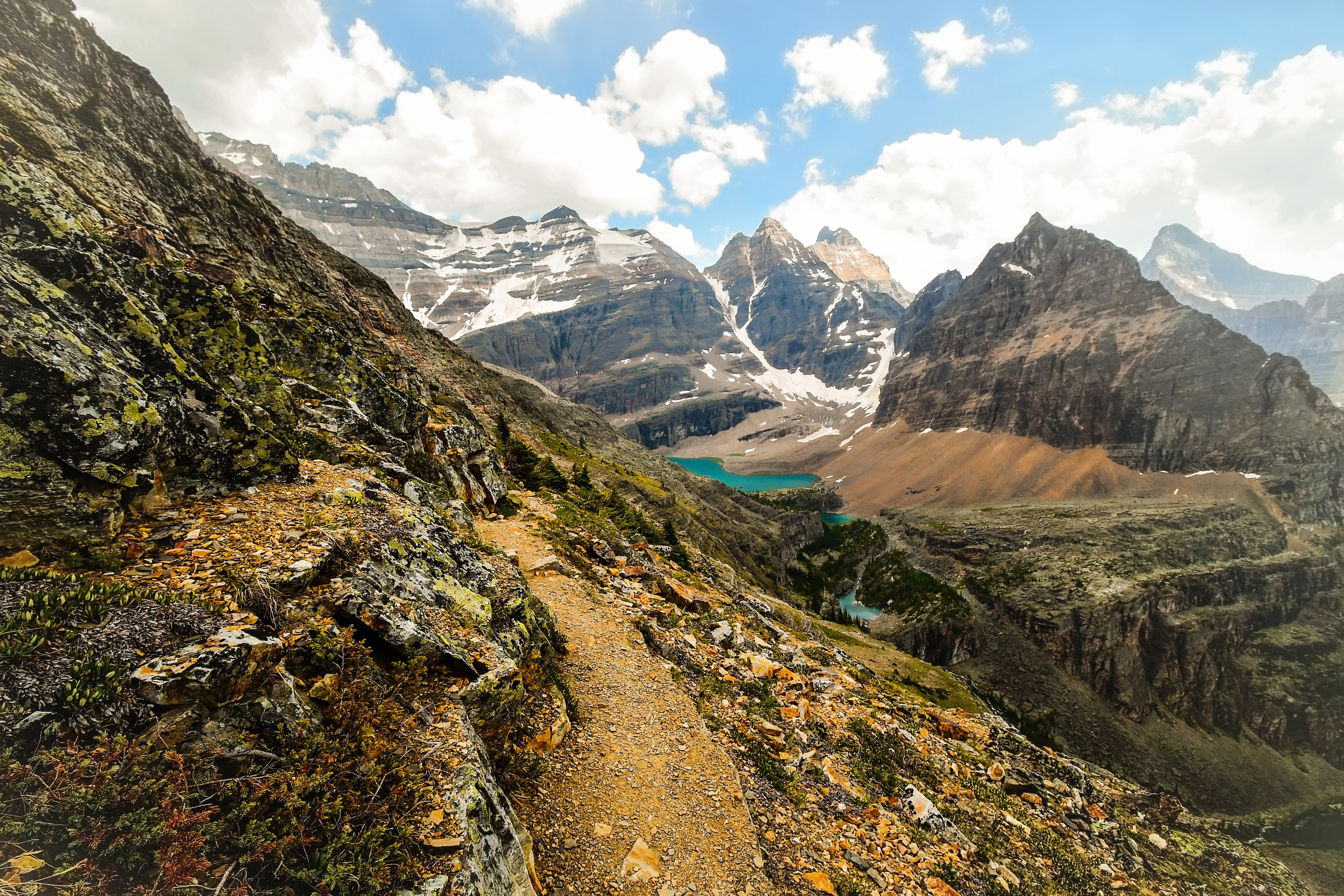 Sentiero di montagna rocciosa che conduce a un lago in una valle Foto