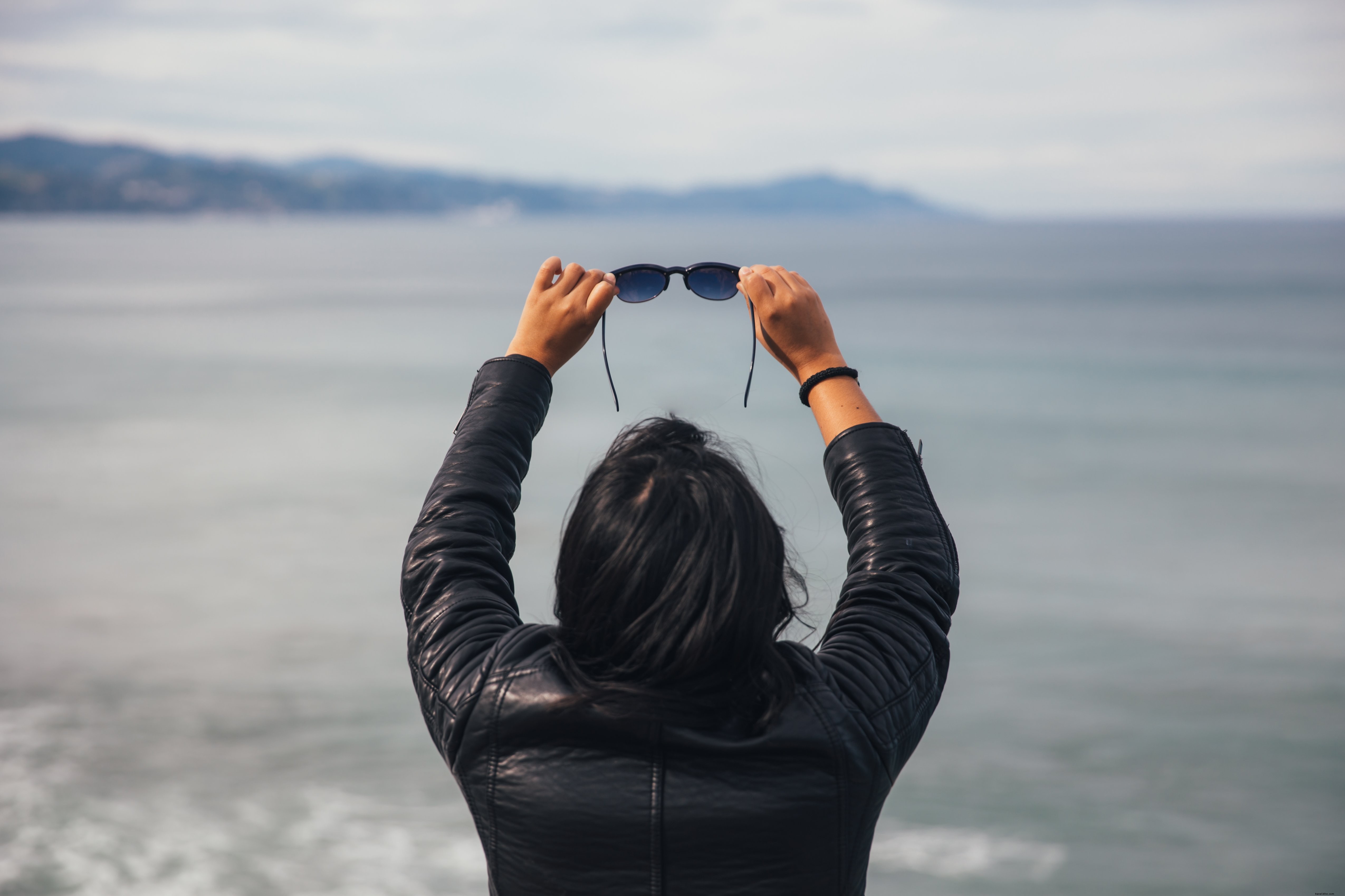 Foto de mulher segurando óculos de sol