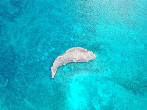 青い海の浅瀬の小さな岩の島写真