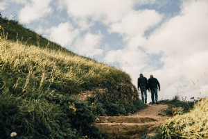 Uomini che fanno escursionismo sulle colline erbose foto