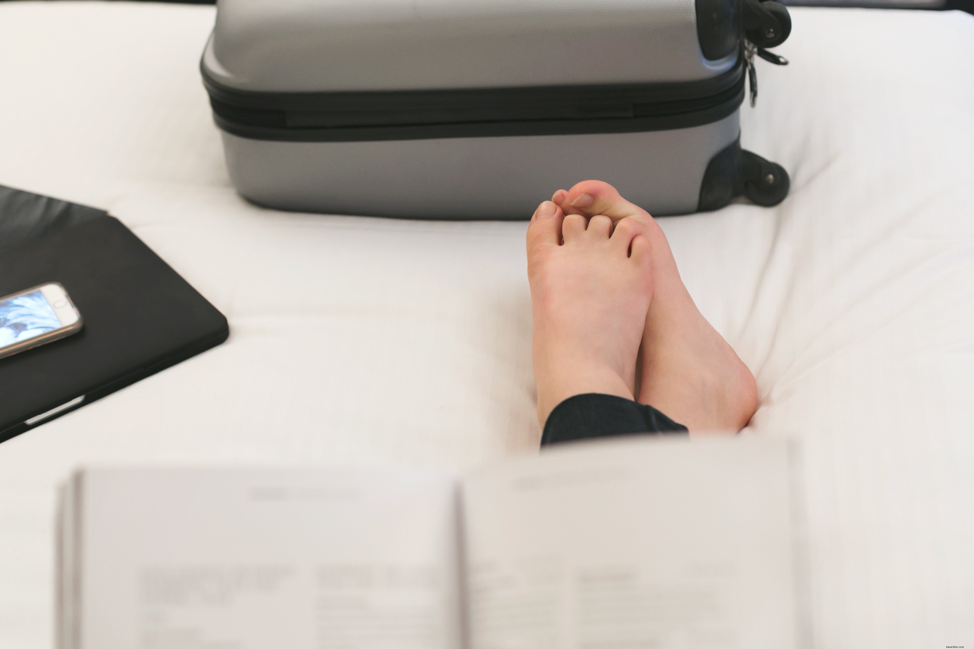 Leyendo en la foto de la cama del hotel