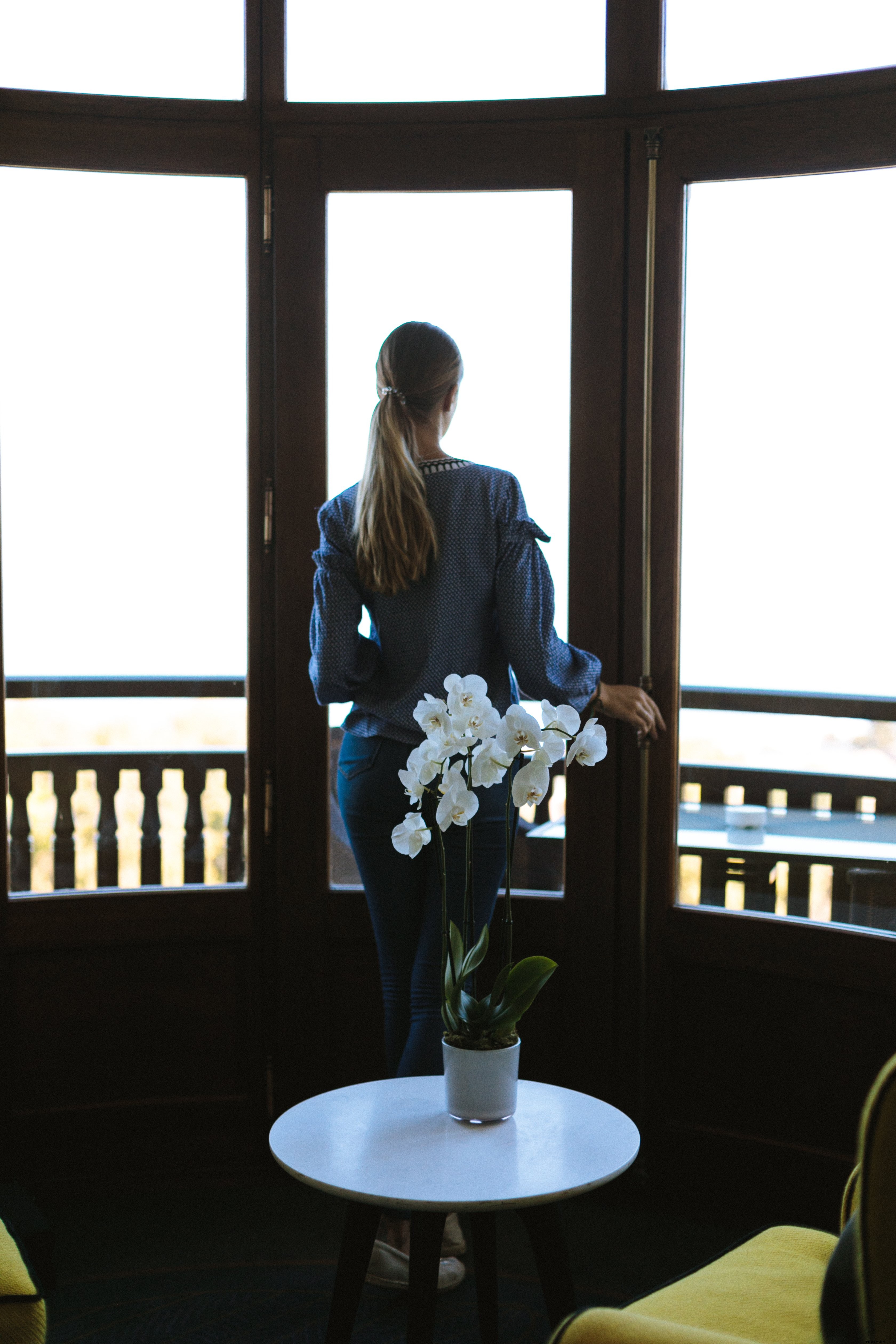 Decoração de orquídeas e mulher apreciando a vista da foto