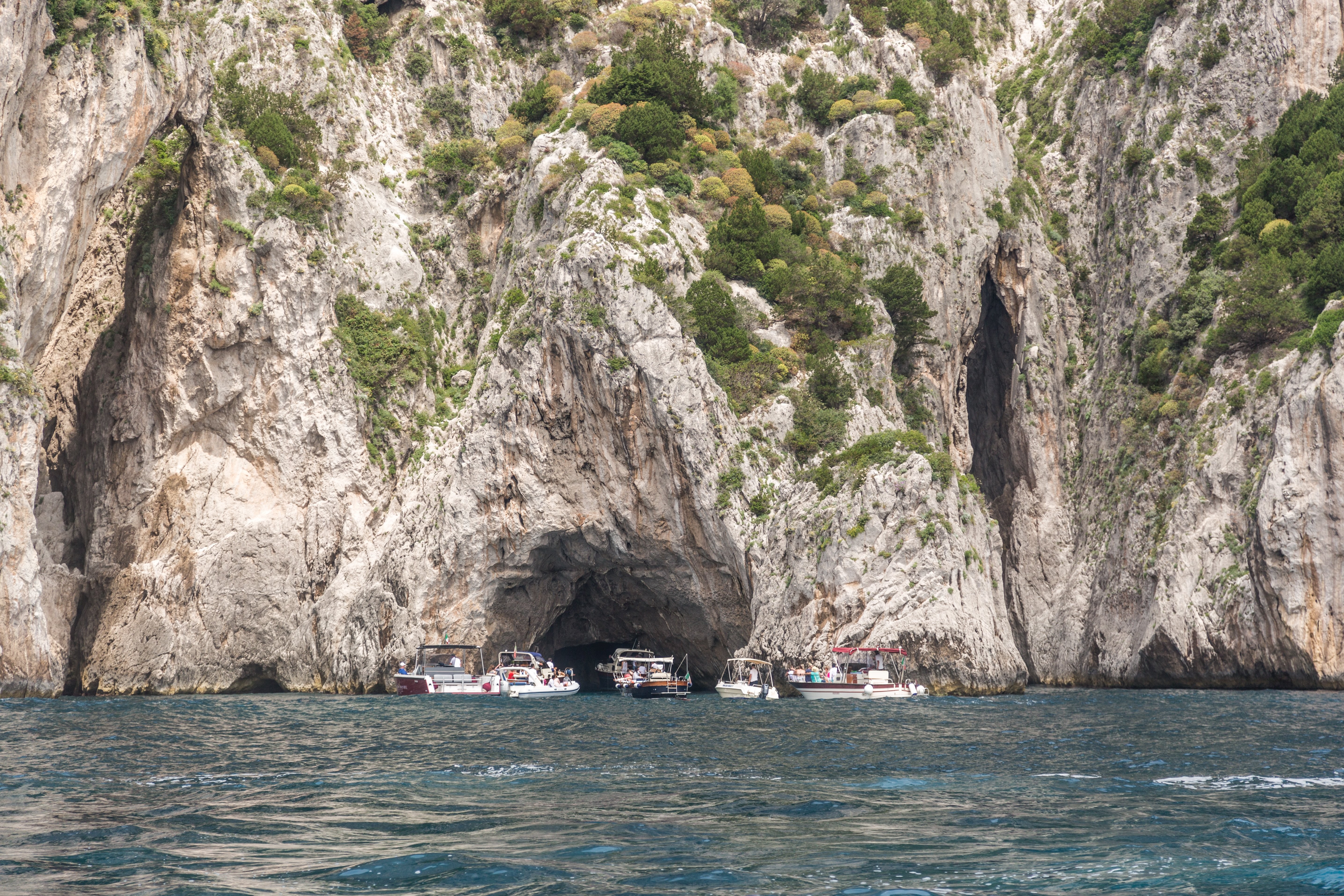 Foto de barcos reunidos em frente à caverna