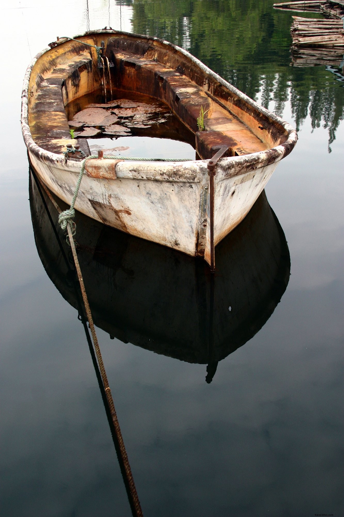 Foto de barco de rio enferrujado em águas claras