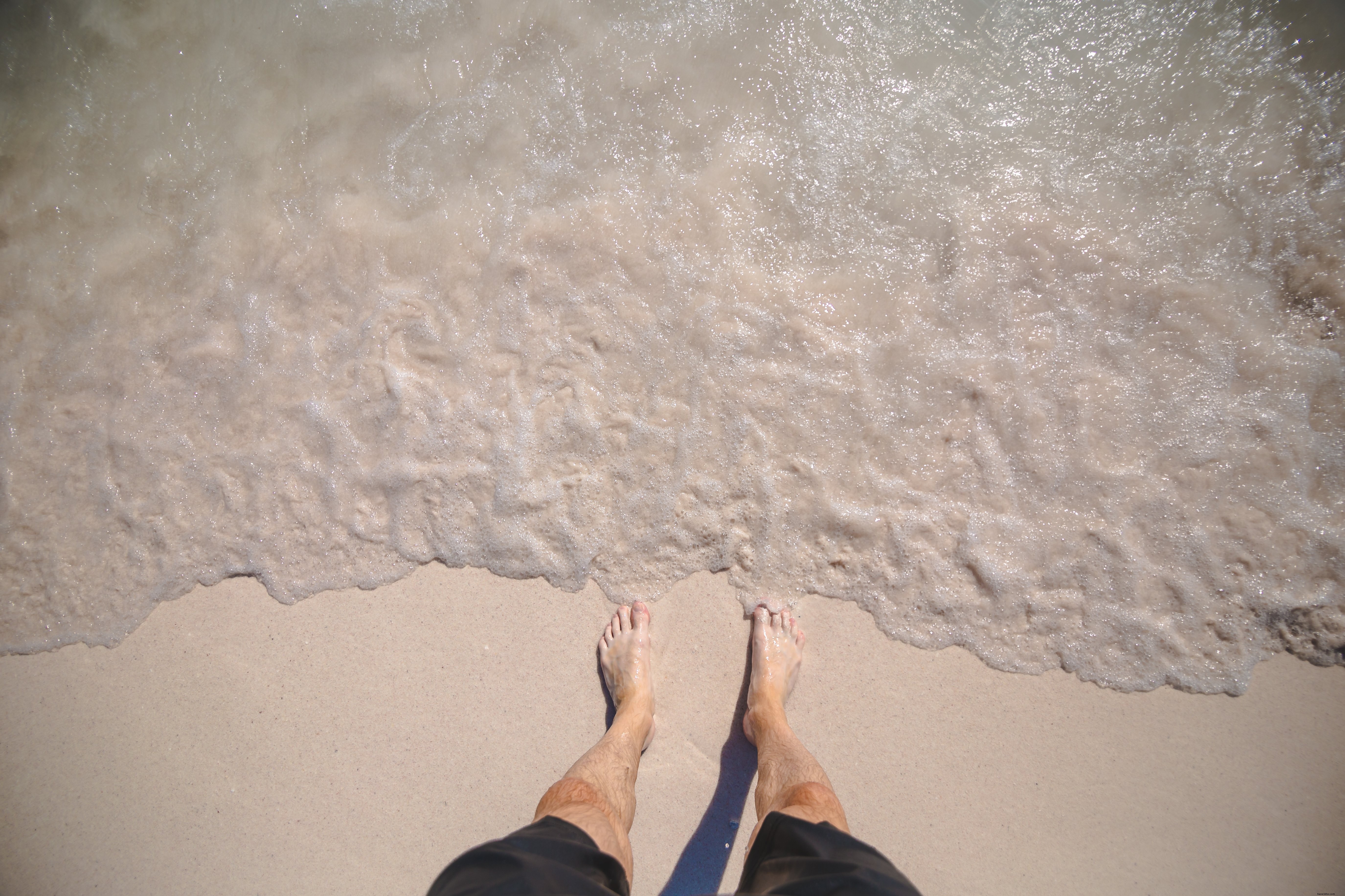 Mans pieds sur Ocean Shore Photo