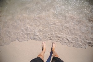 Fotos de pies de hombre en la orilla del océano