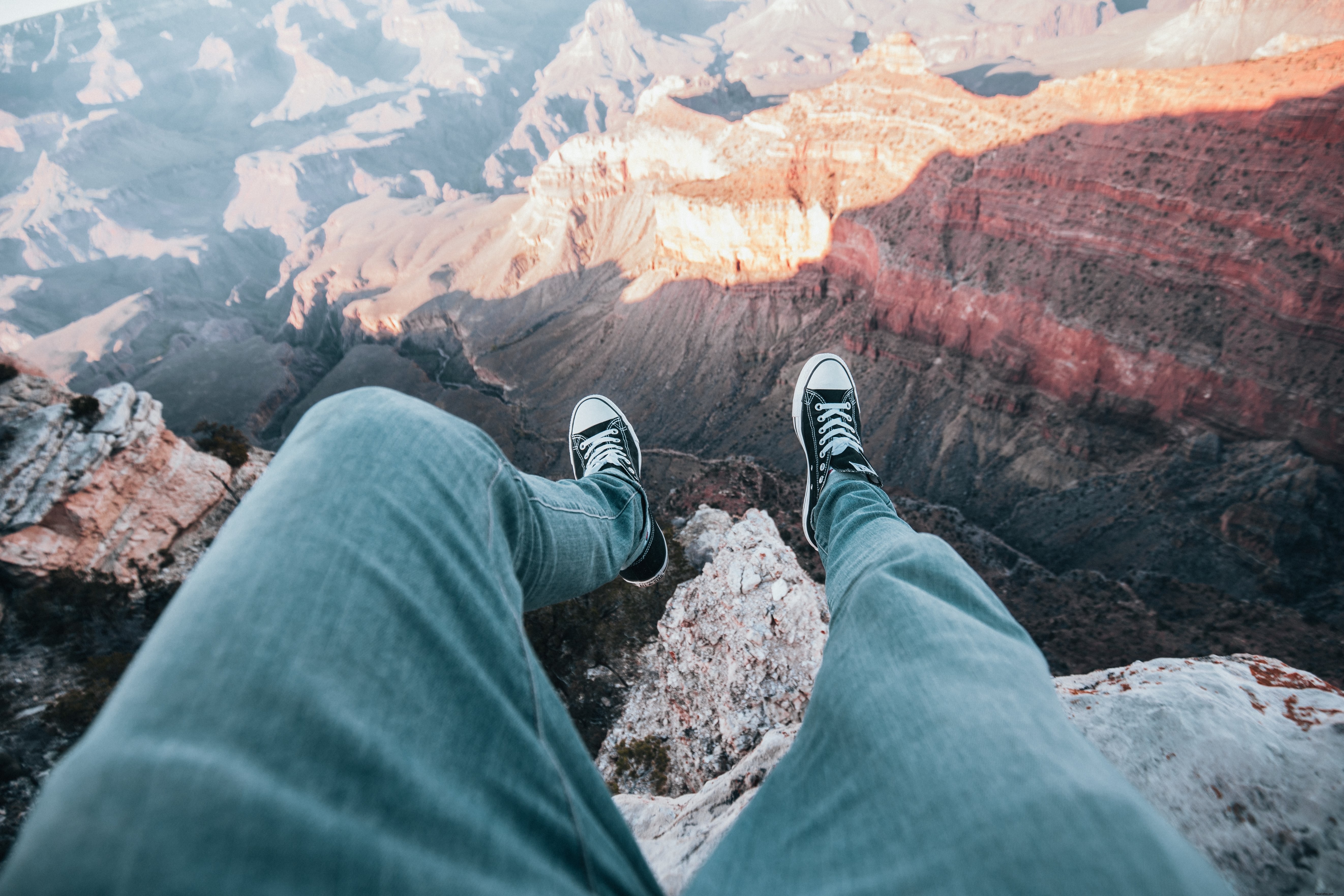 Les jambes de l aventurier pendent au-dessus de la photo du bord du canyon