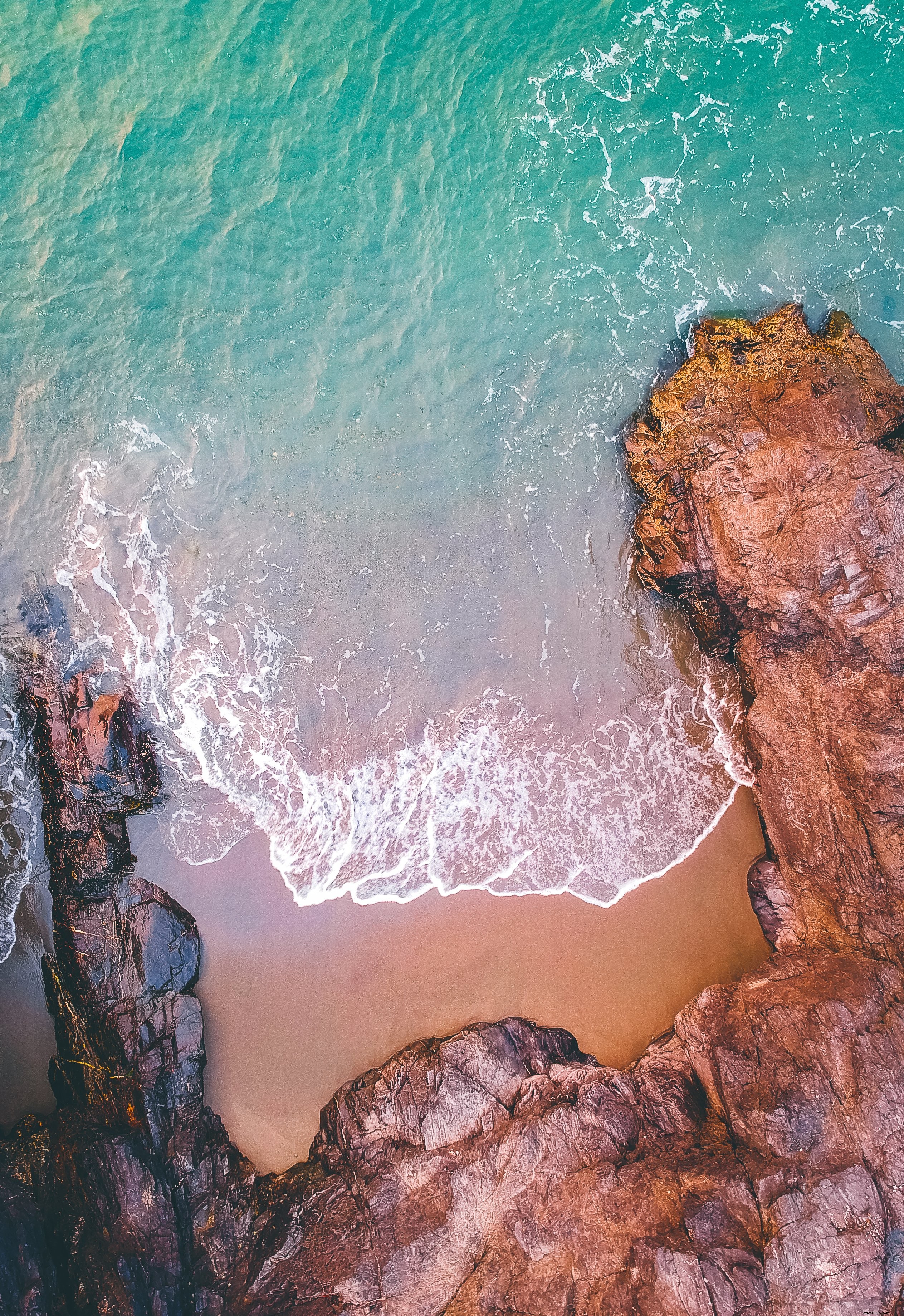 Vista aerea del mare che rotola in una foto di costa rocciosa