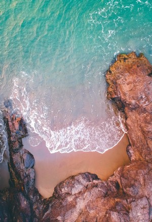 Foto de vista aérea do mar entrando em uma costa rochosa