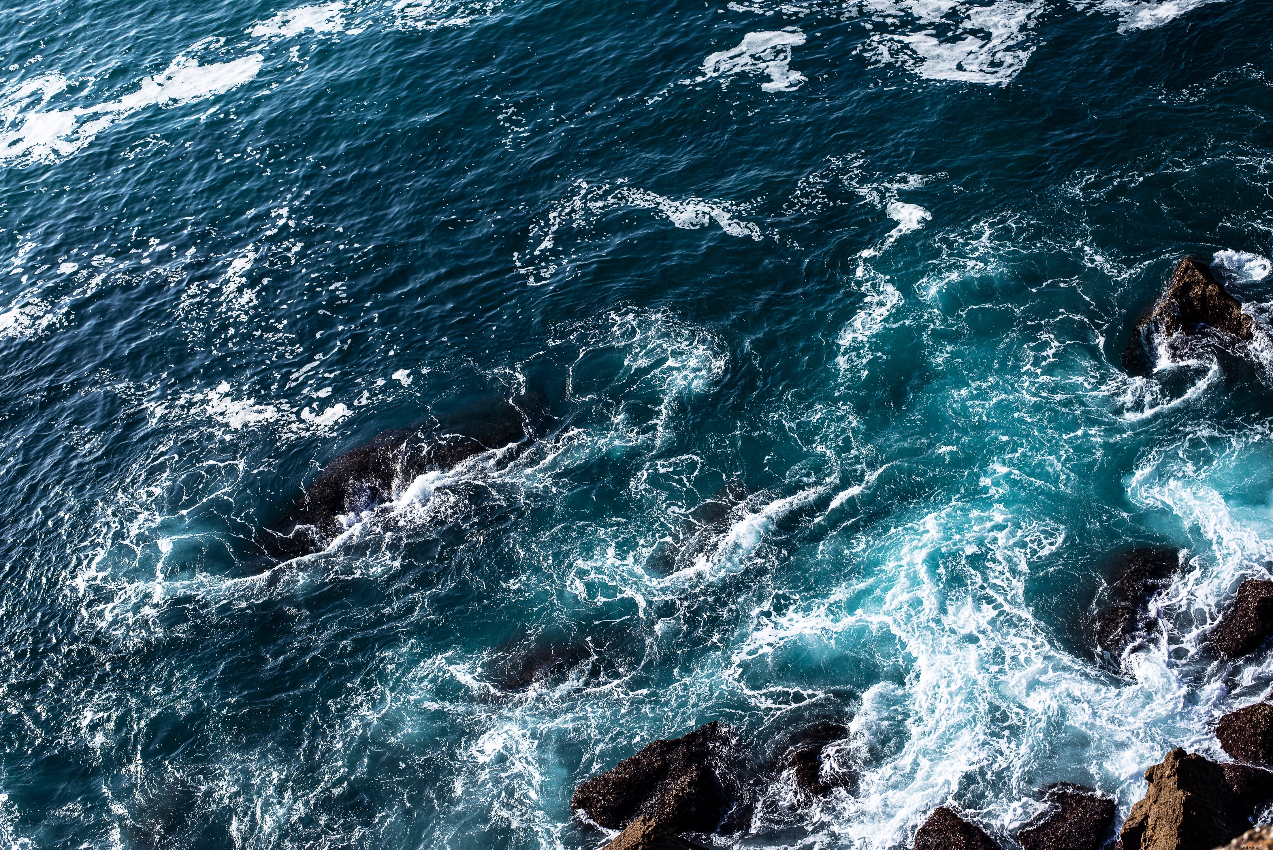 L eau bleue moussante roule sur les rochers Photo