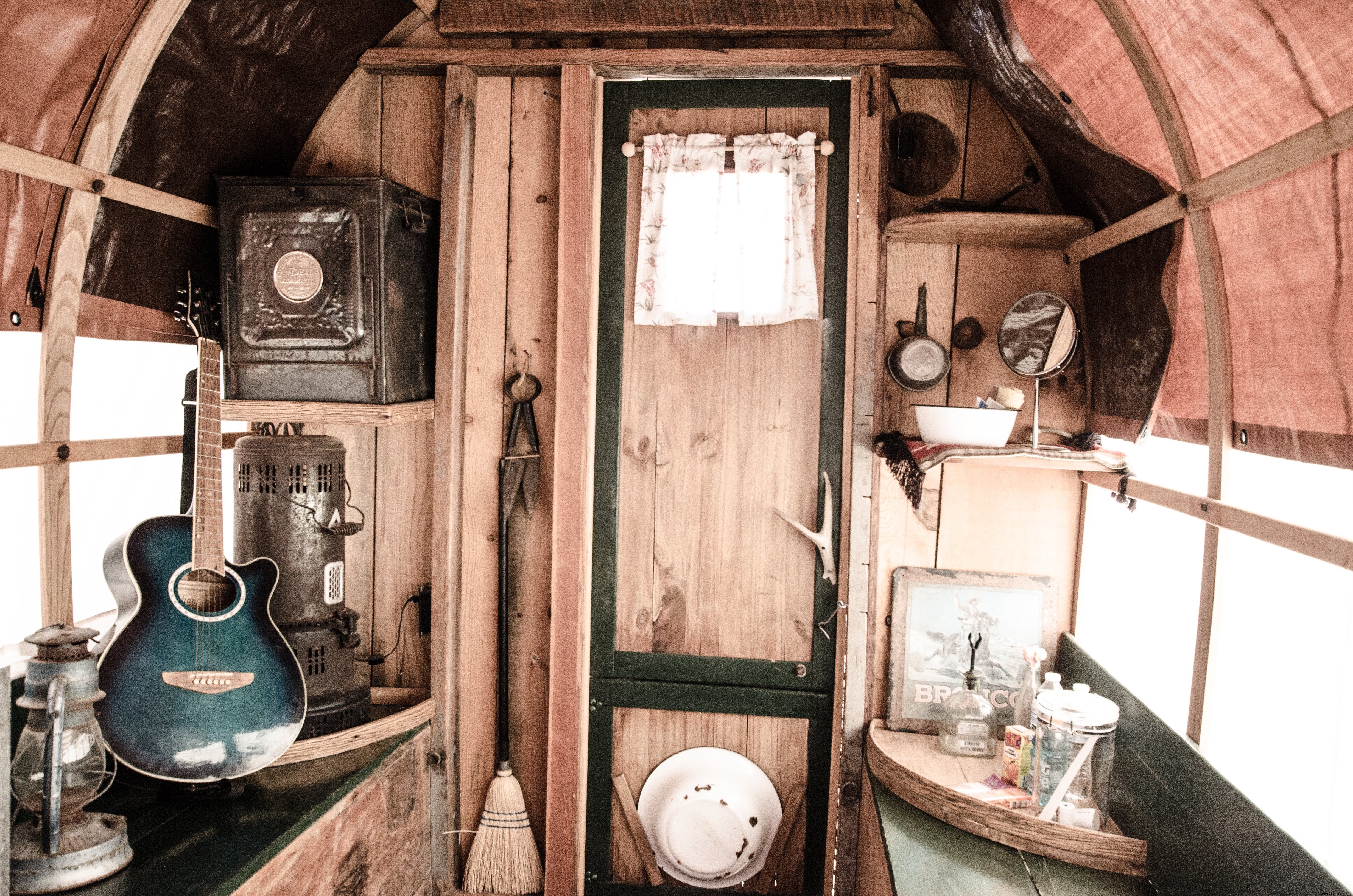 Foto de objetos domésticos rústicos e musicais dentro de uma caravana