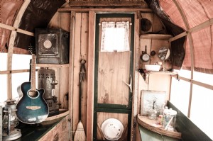 Foto de objetos domésticos rústicos e musicais dentro de uma caravana