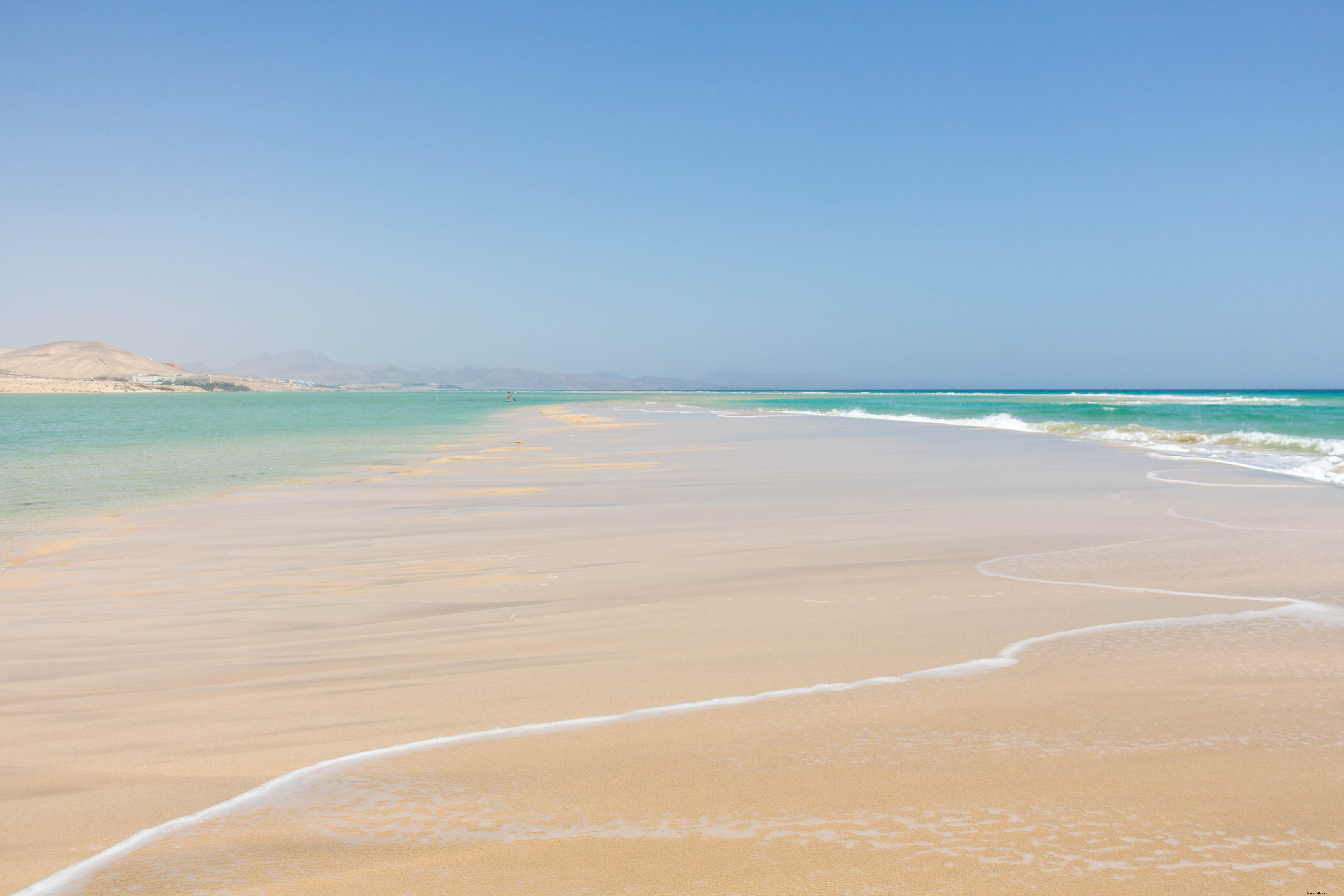 青い海の水の間の砂のバー写真
