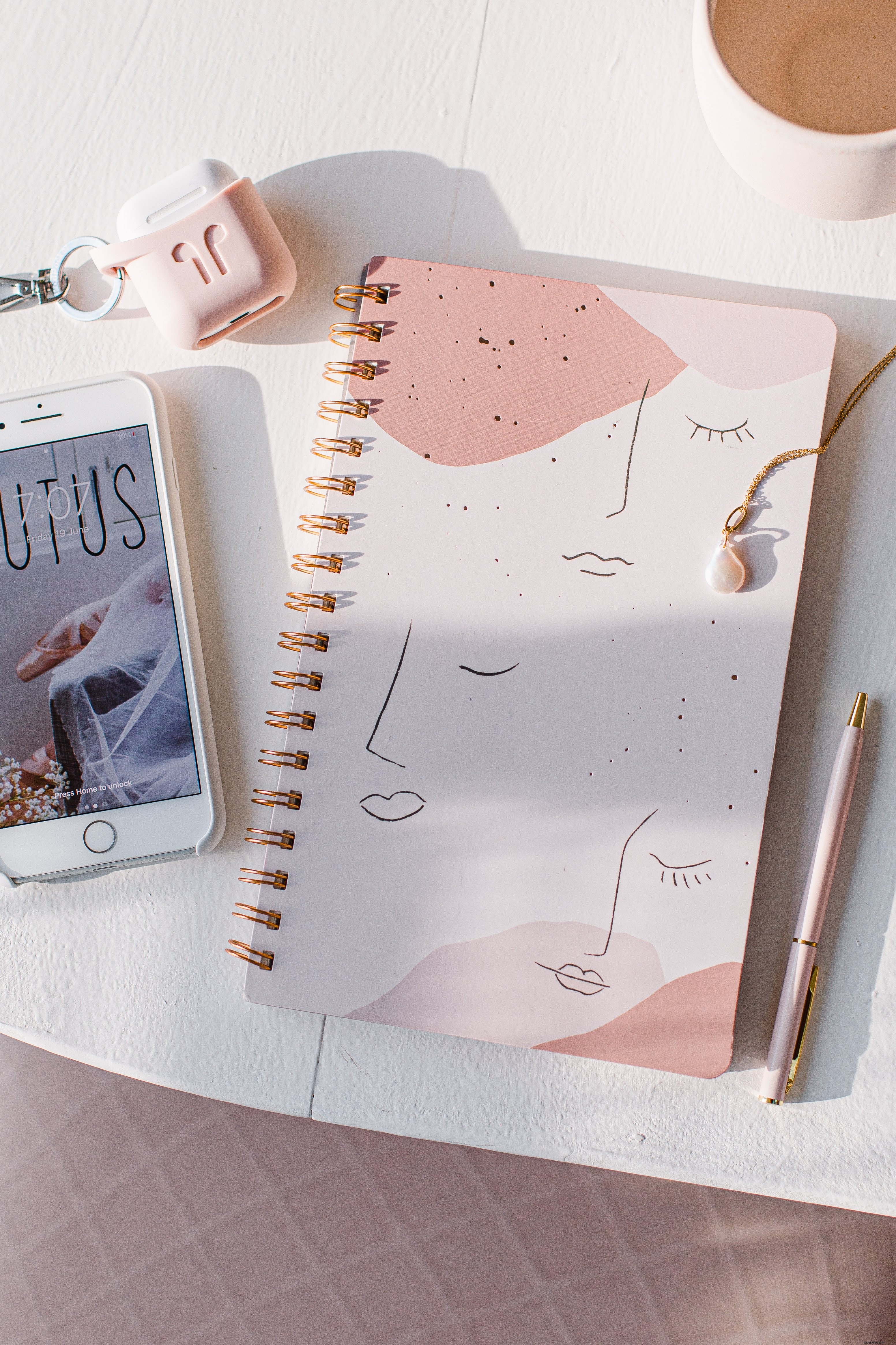 Flatlay de un cuaderno con bolígrafo y foto de teléfono móvil