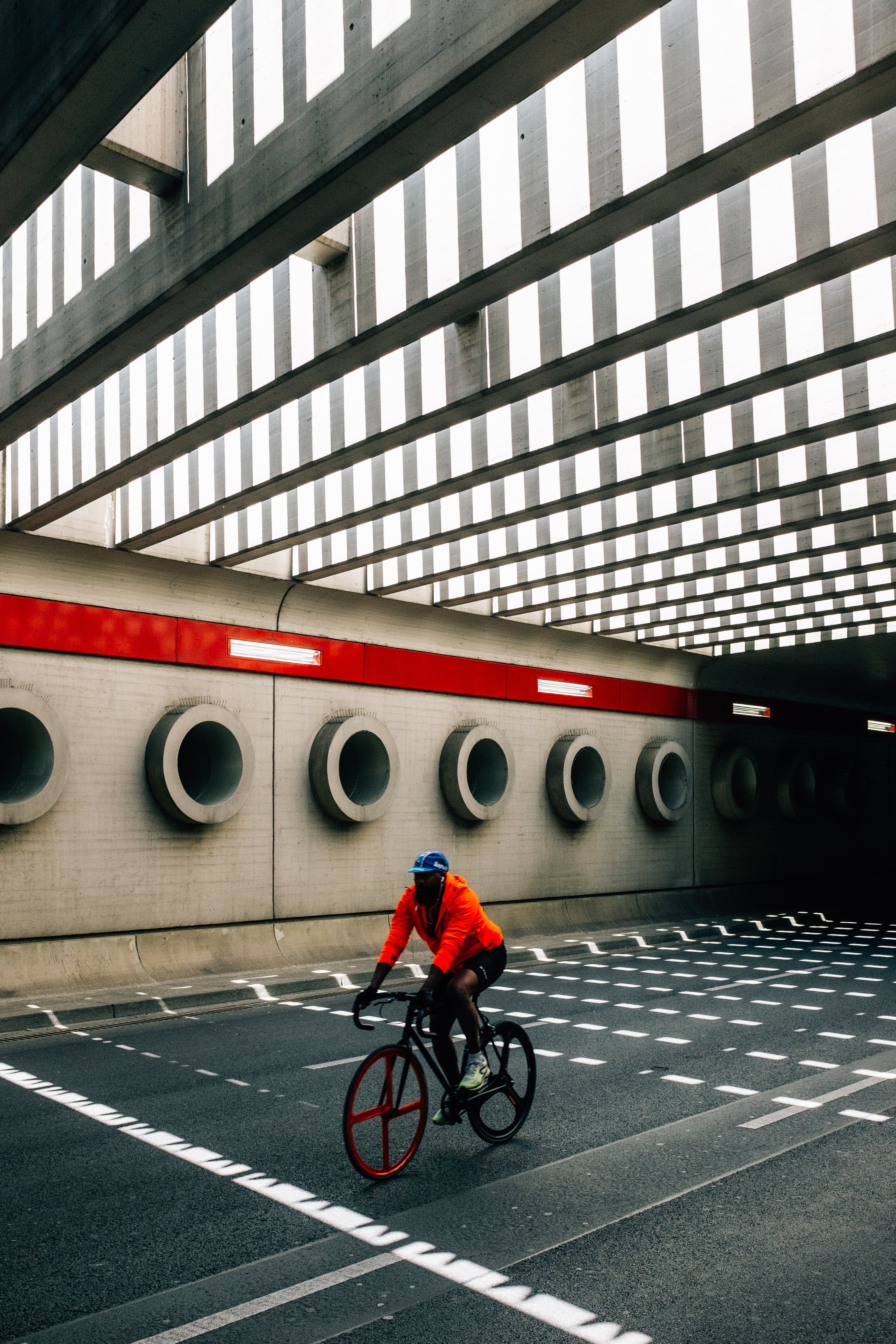 Persona en naranja paseos en bicicleta debajo del puente Foto