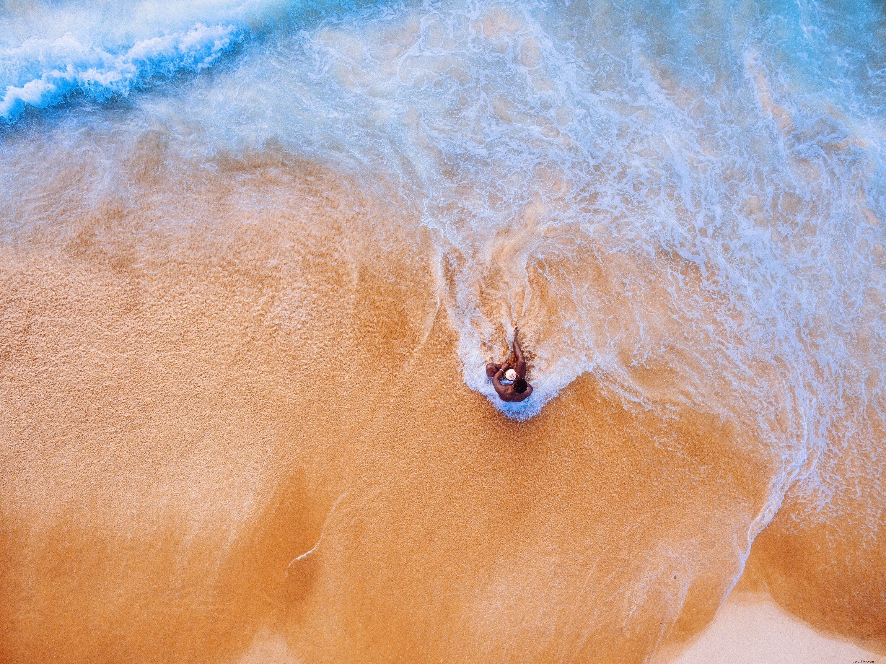 Il giovane si siede sulla foto della spiaggia