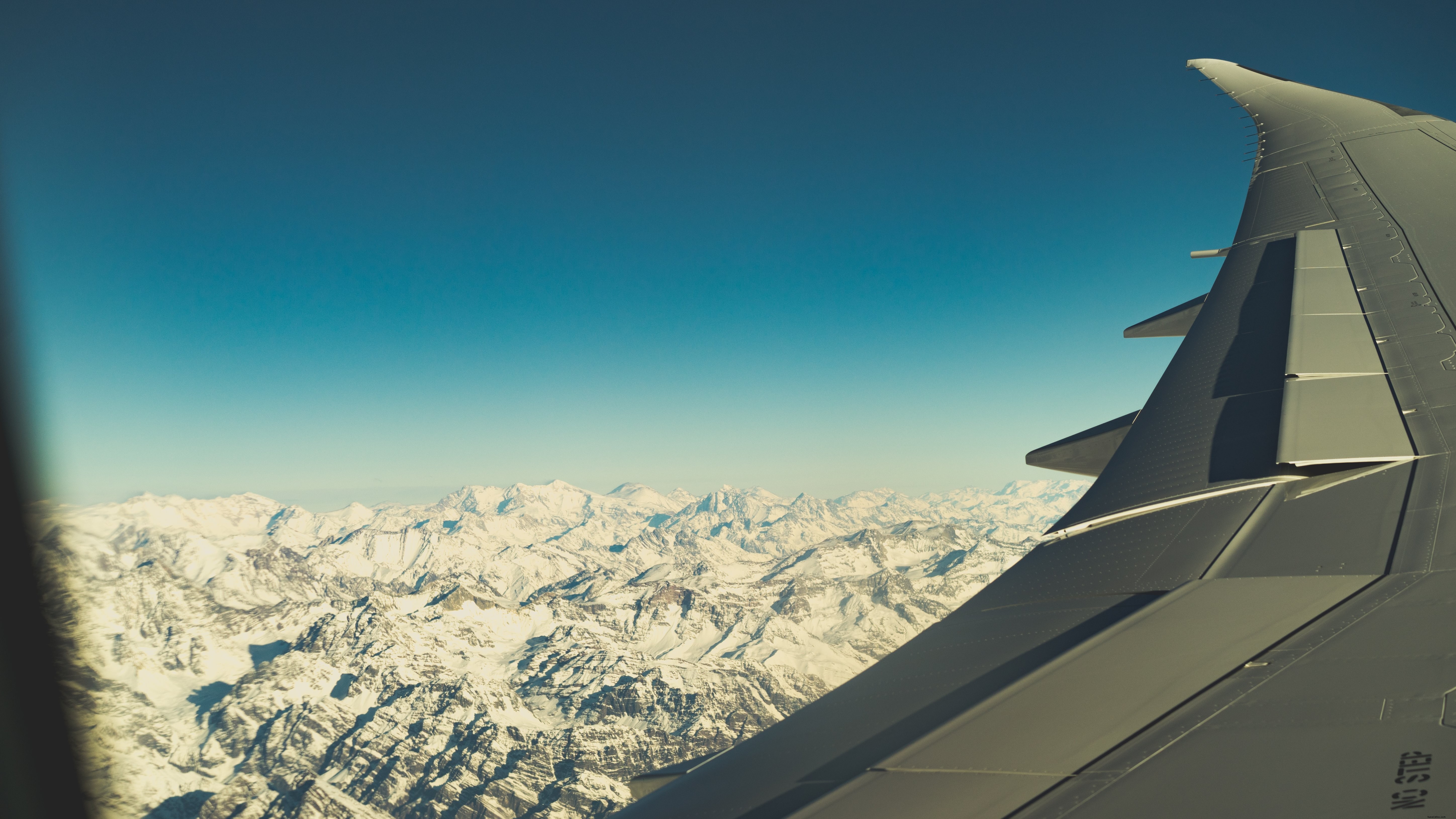 Foto de picos nevados na janela da aeronave