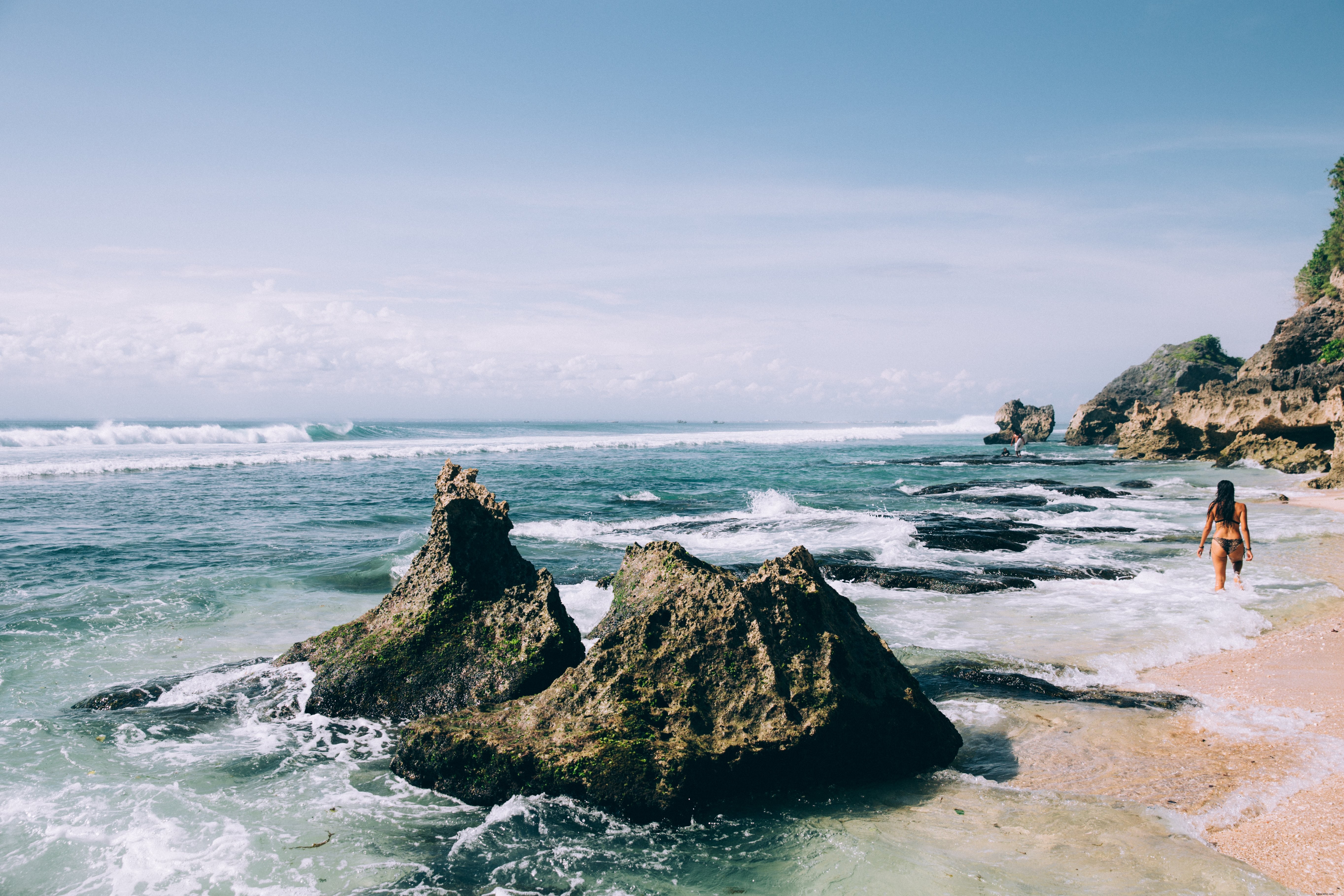 Mulher de biquíni caminhando ao longo da praia. Foto