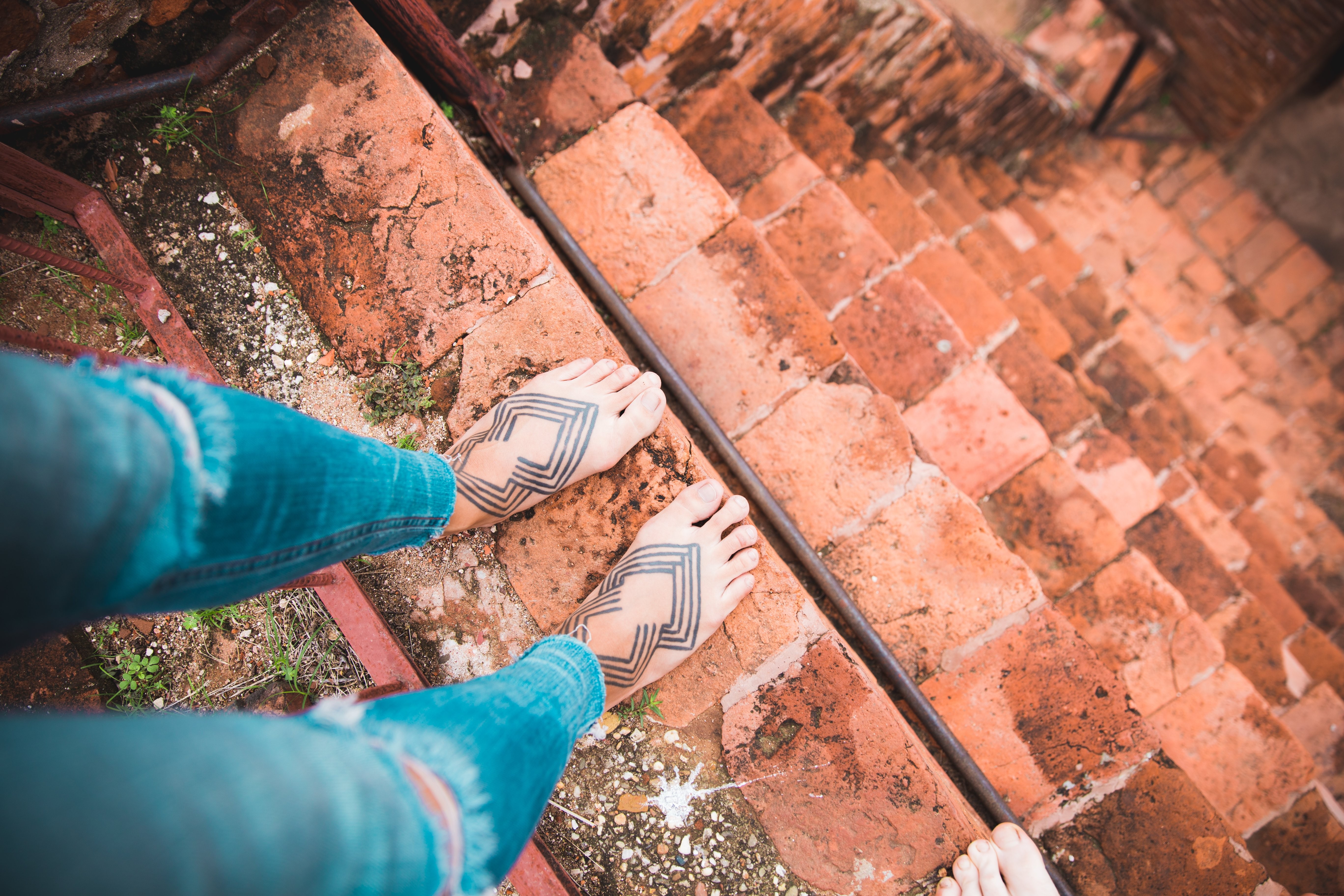 Foto de pies tatuados en escaleras empinadas