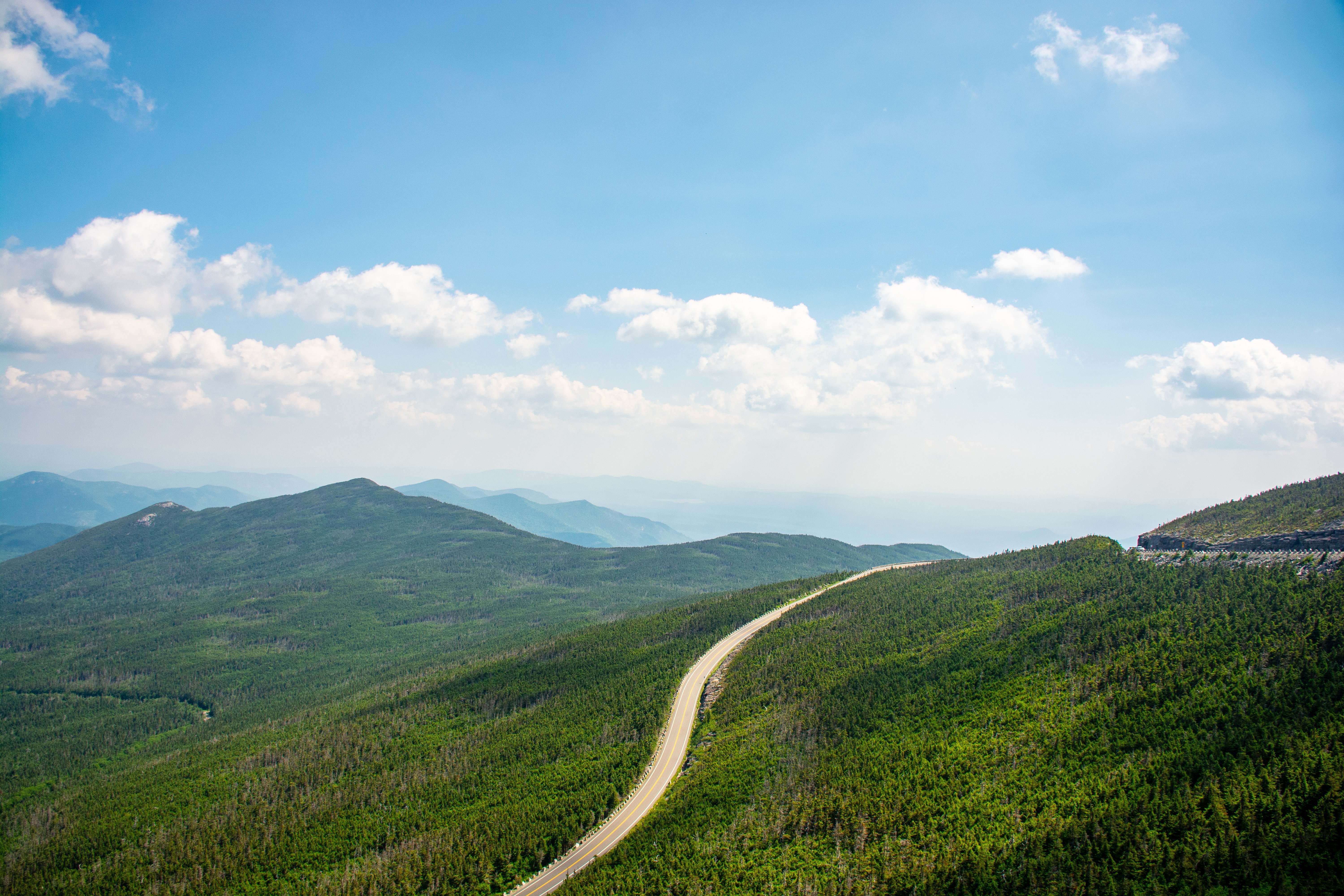 Una sola carretera se arremolina a través de un paisaje montañoso Foto
