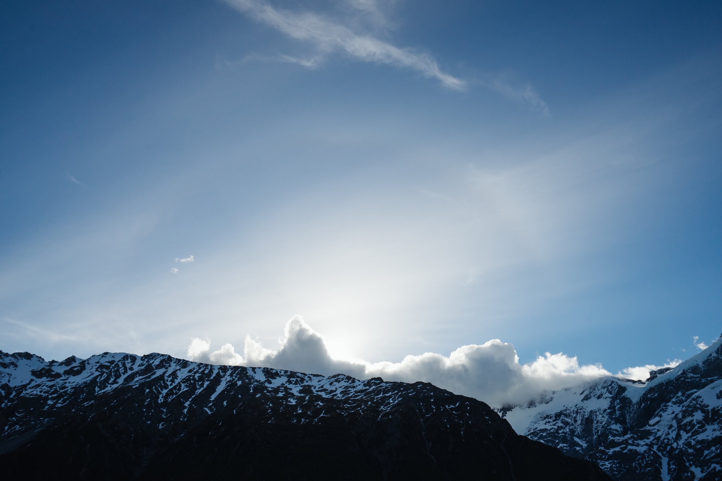 Ciel bleu vif au-dessus des nuages ​​touchant la photo du sommet des montagnes