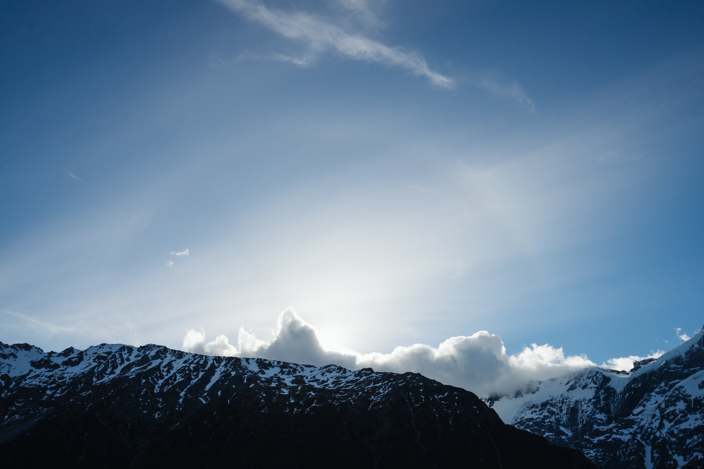 Céu azul brilhante sobre nuvens tocando a foto do Mountiantops