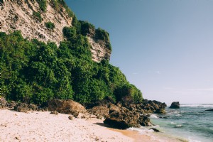 Praia cercada por penhascos rochosos e fotos da selva