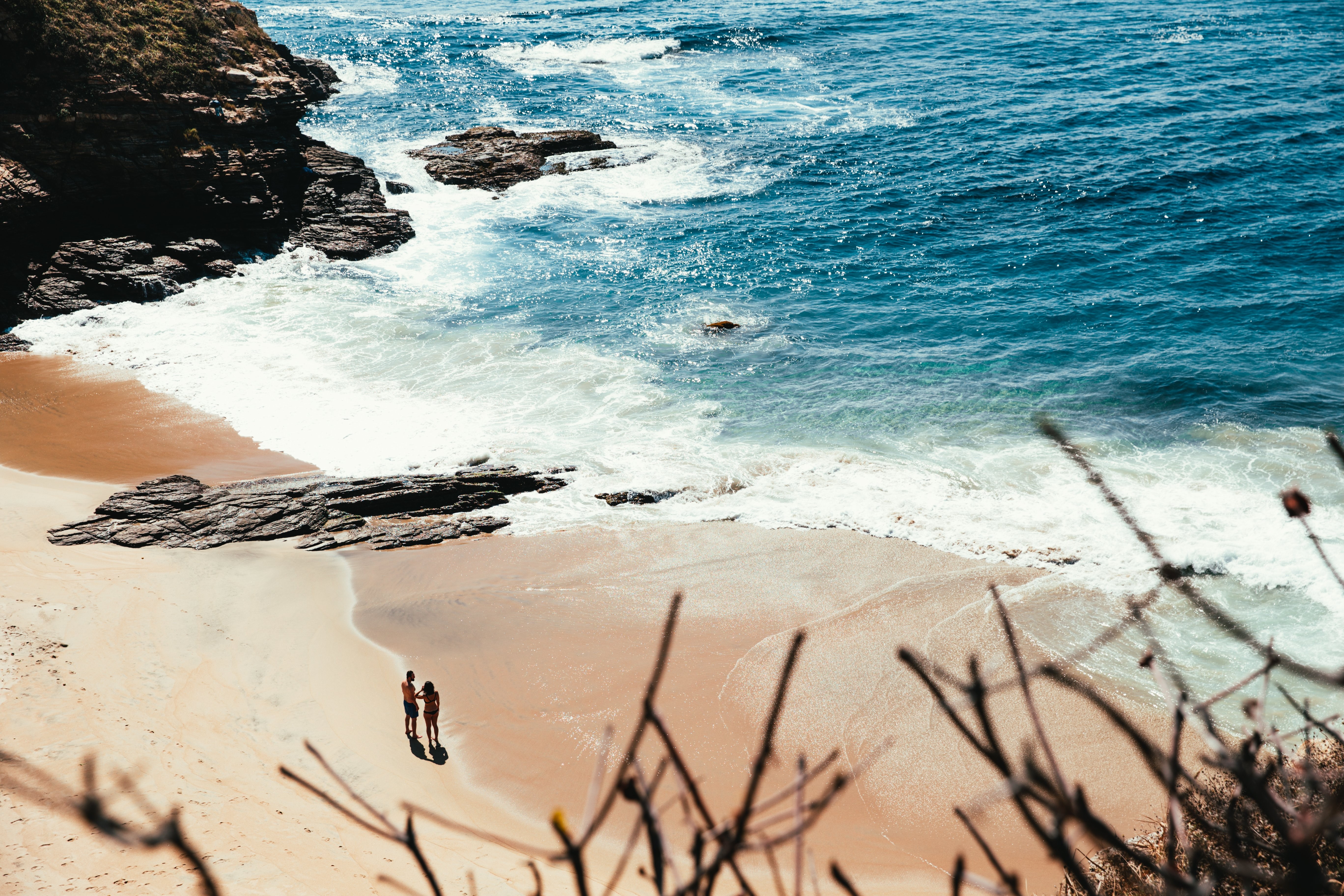 Foto de casal em pé à beira-mar