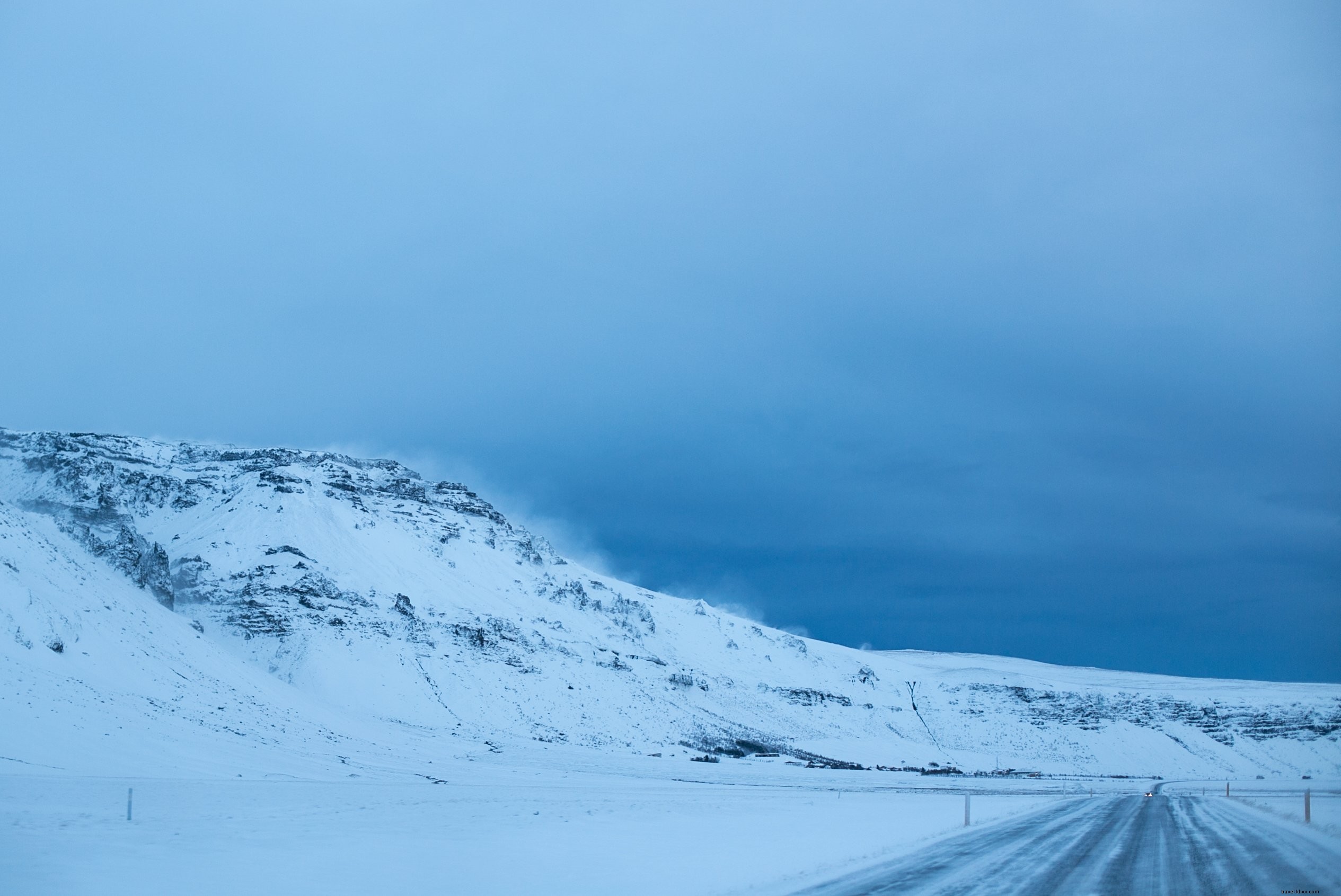雪をかぶったアイスランドの丘の中腹の写真