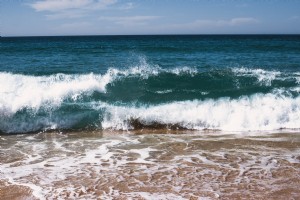 紺碧の水が海岸に流れ込む写真