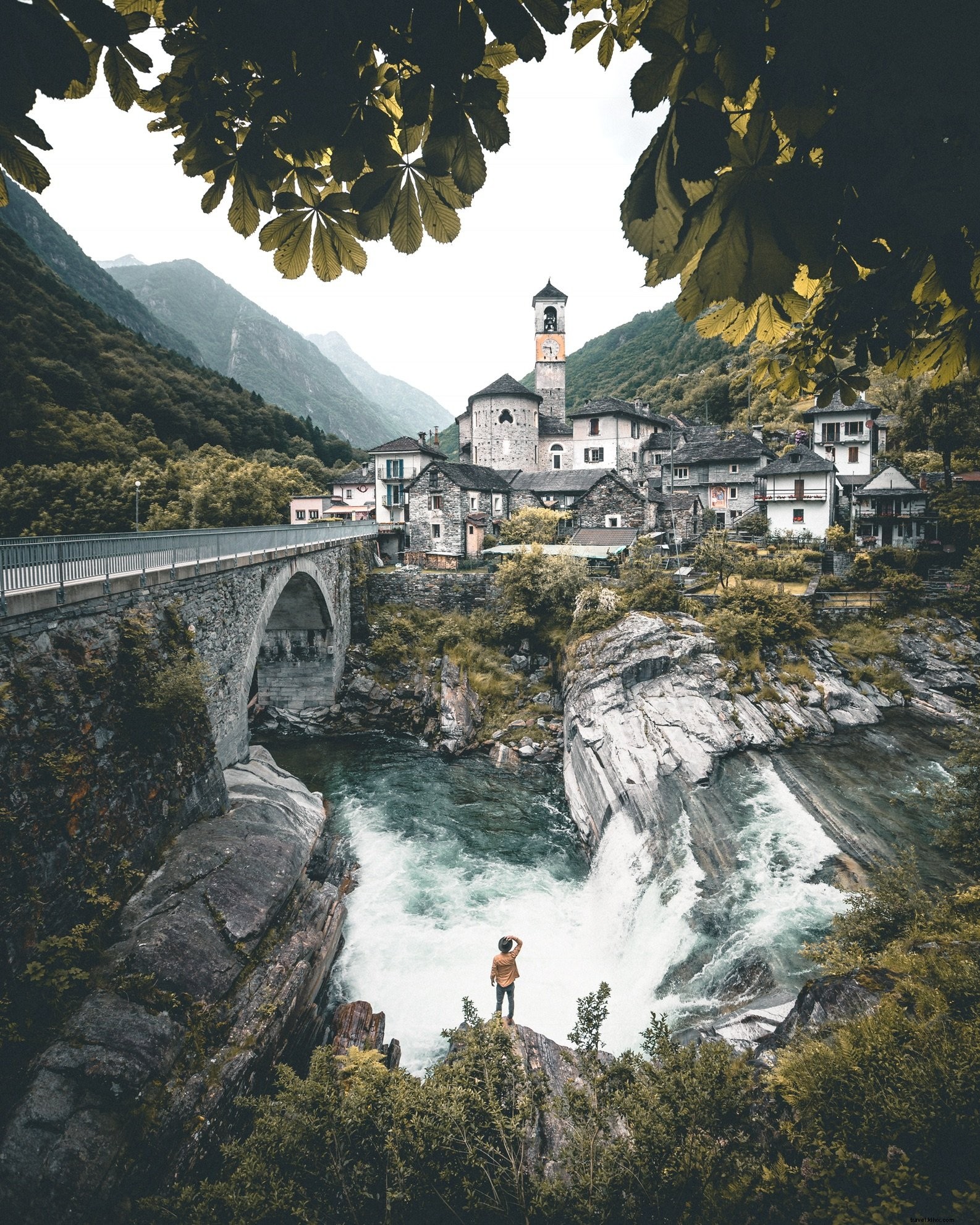 Foto de edificios de piedra construidos al lado de la cascada