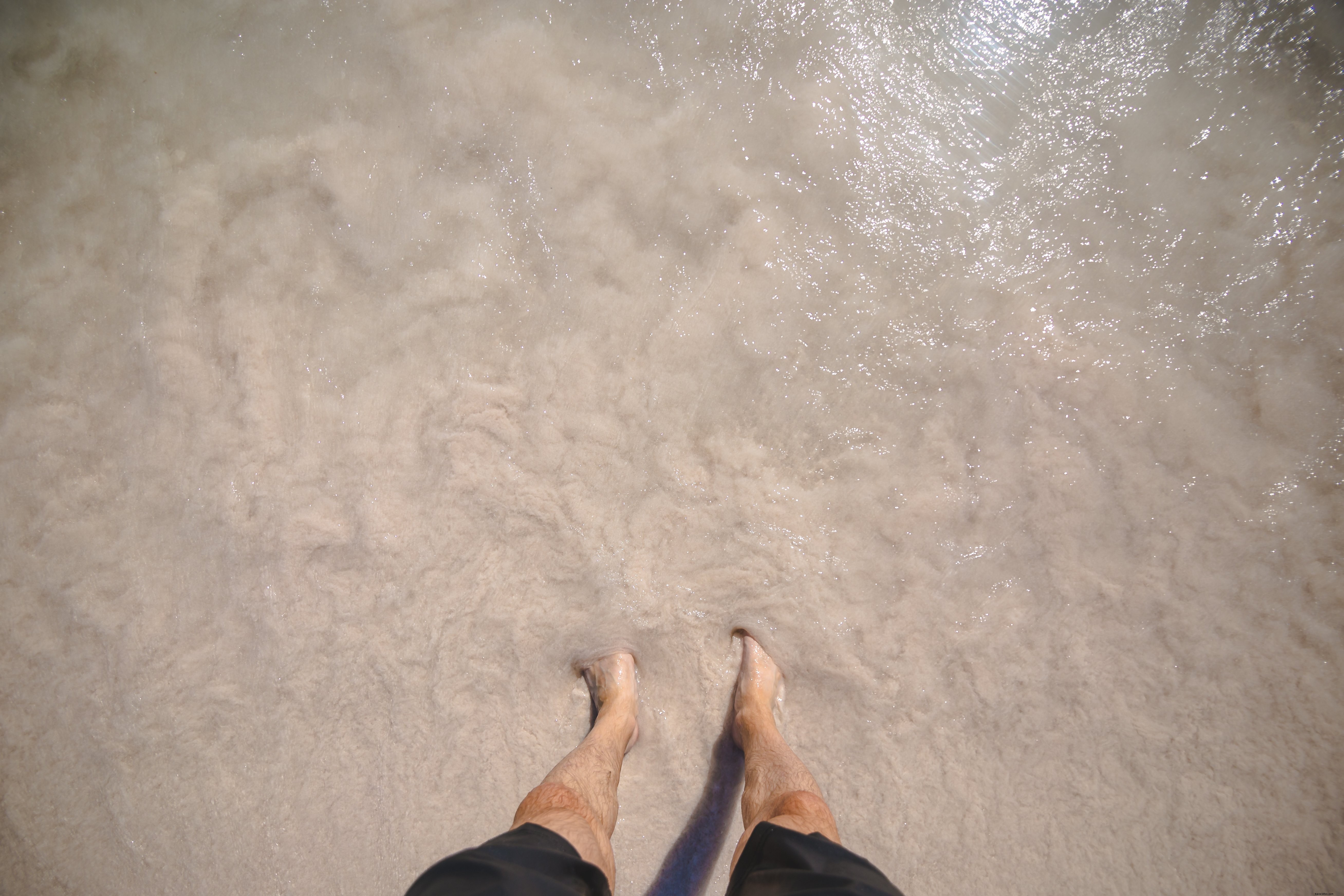 Pies de hombre en foto de agua de playa