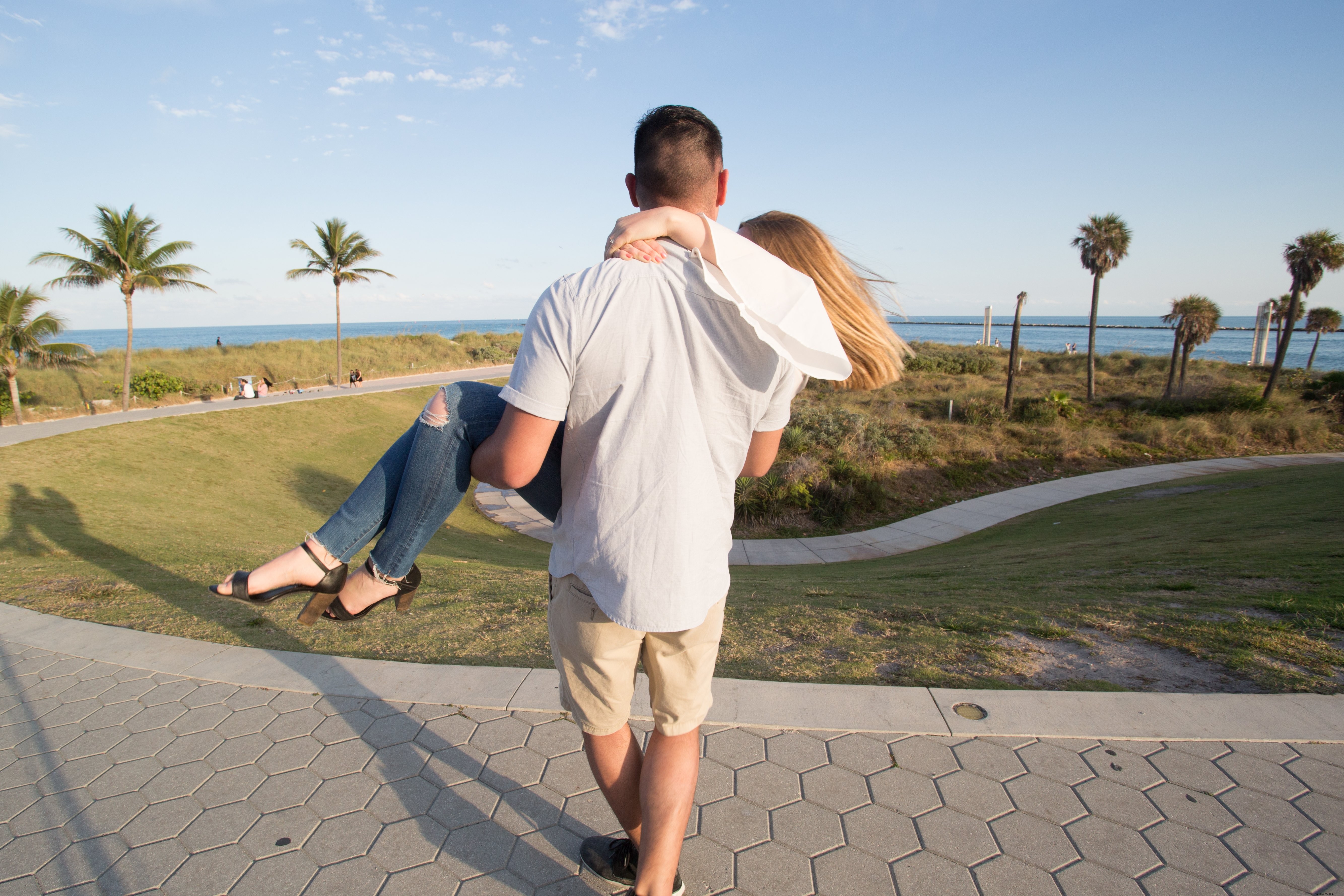 Foto de homem carregando mulher no parque