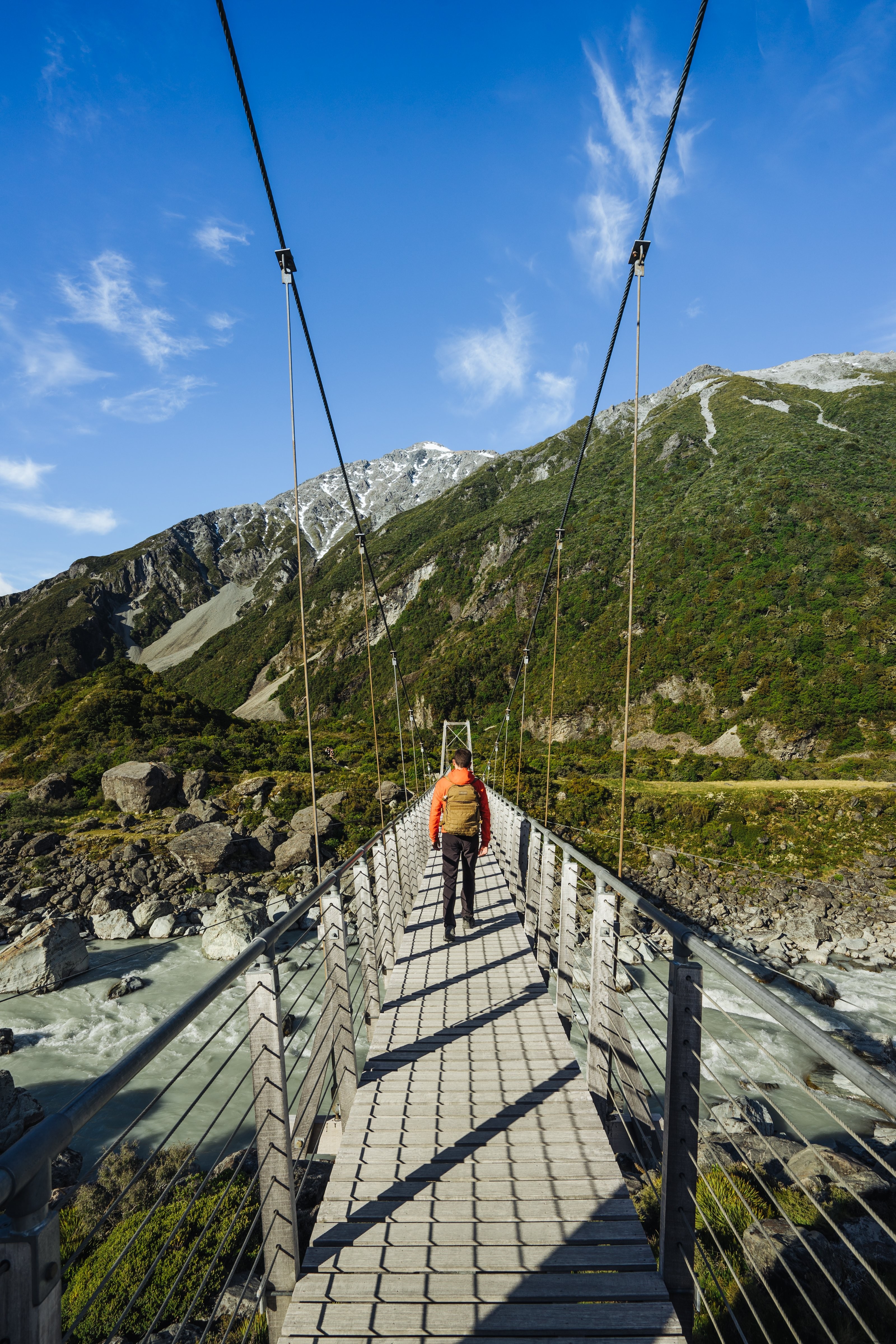 Un homme marchant sur un pont suspendu Photo