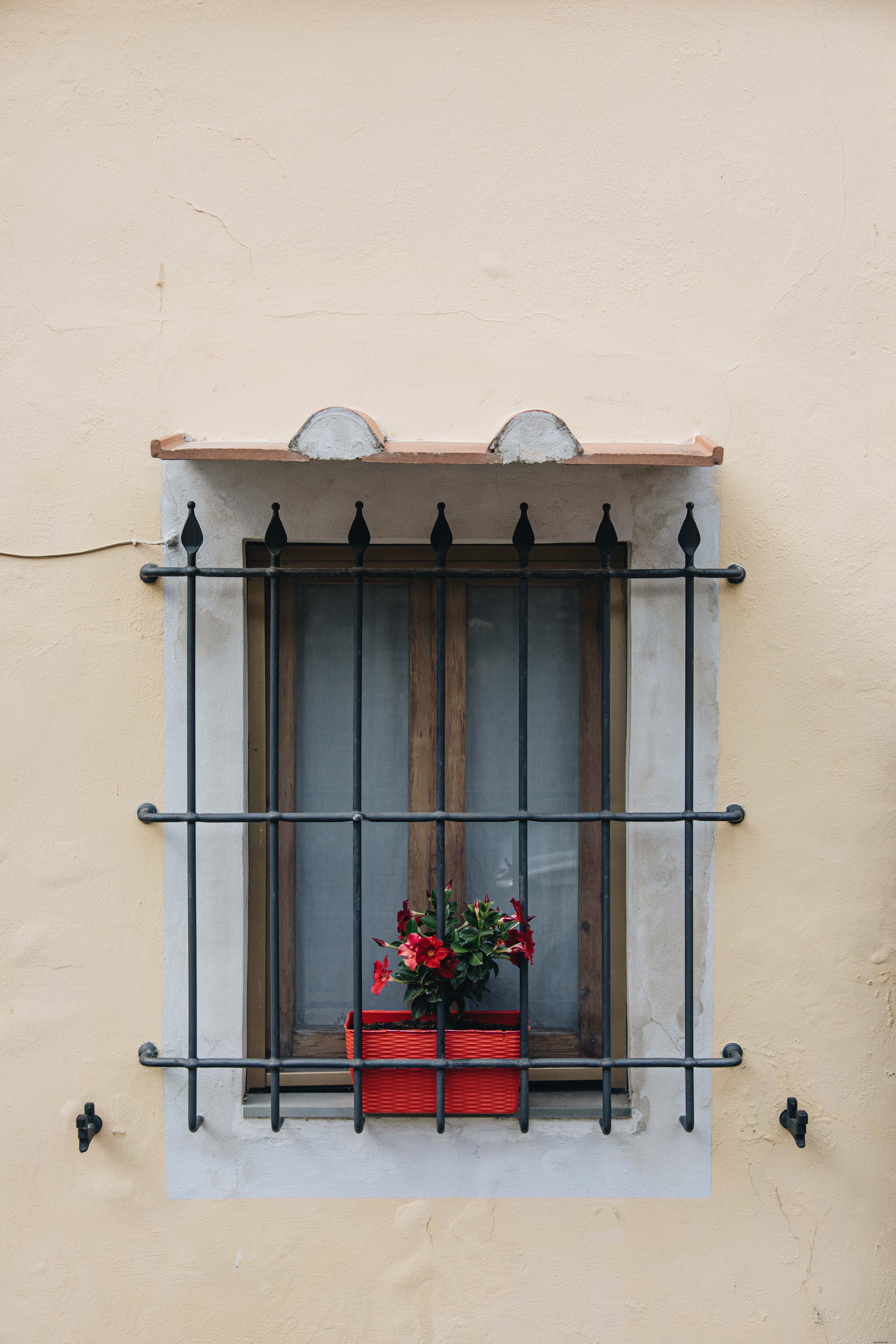 Ventana con protectores de hierro en la foto del edificio amarillo