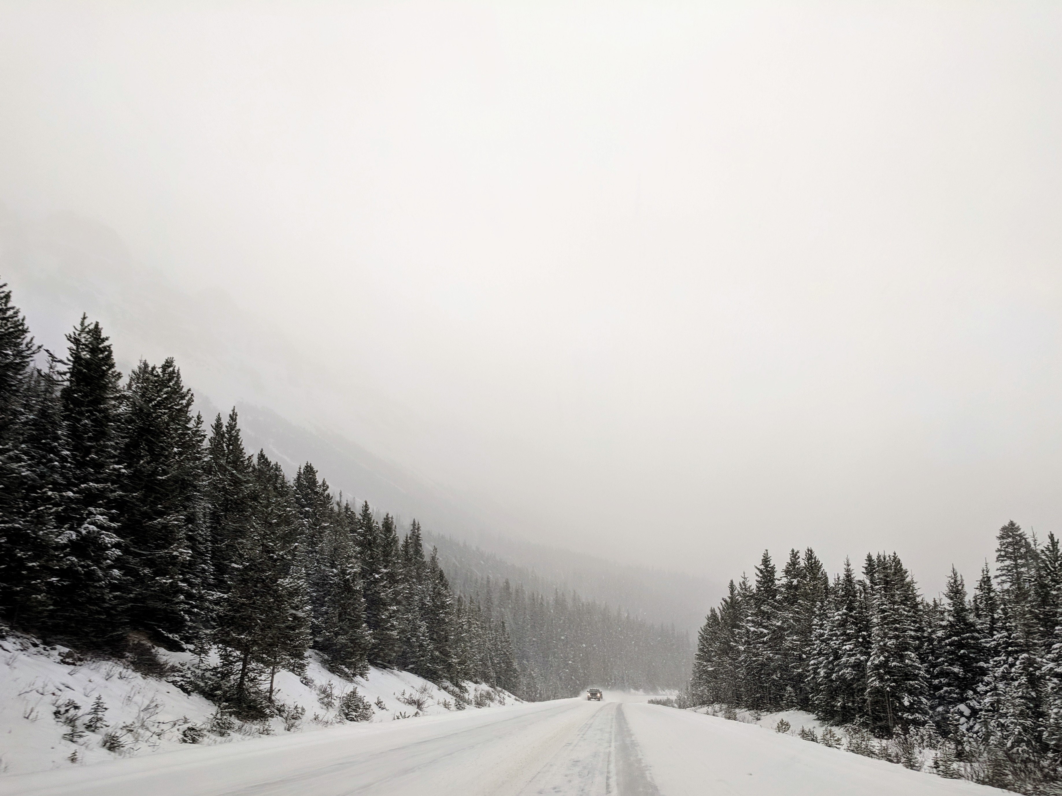 Foto de um único caminhão em uma estrada com neve